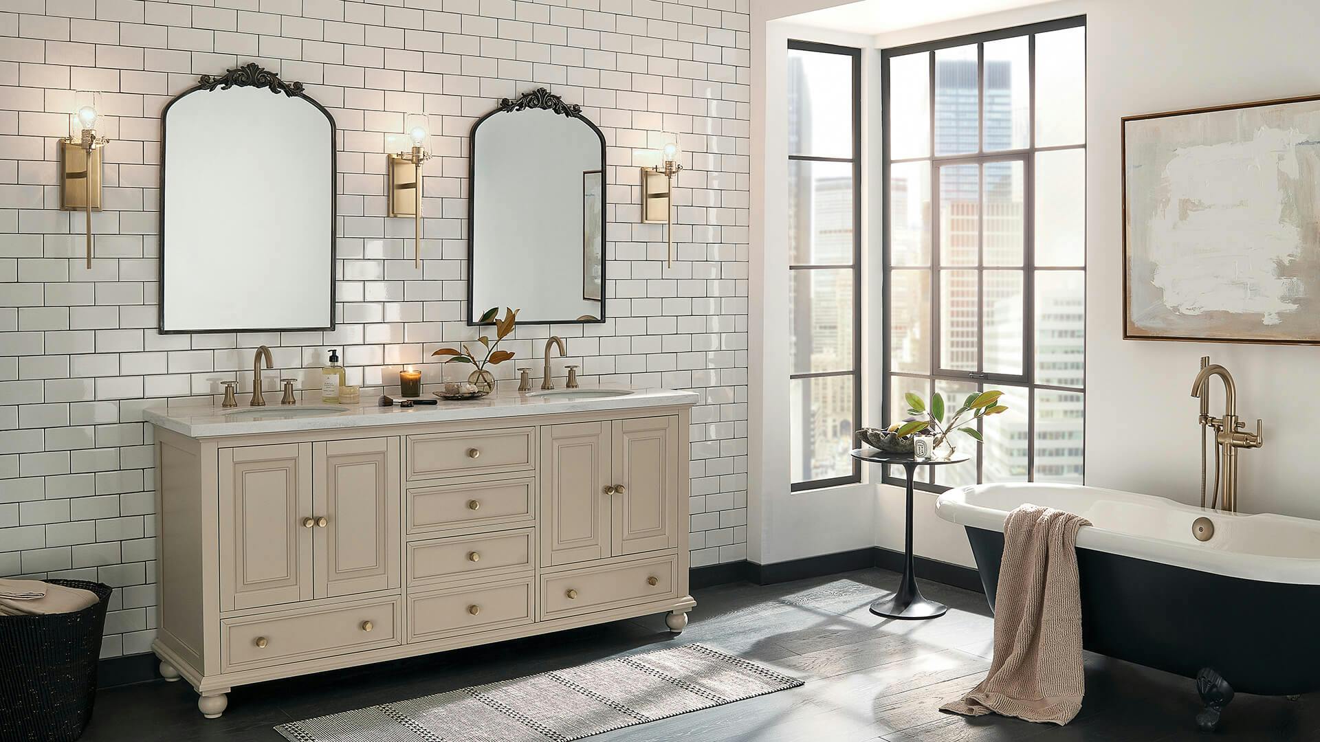 Bathroom during the day with white wall tiles and large windows in a high rise featuring alton gold finish wall sconces next to two mirrors