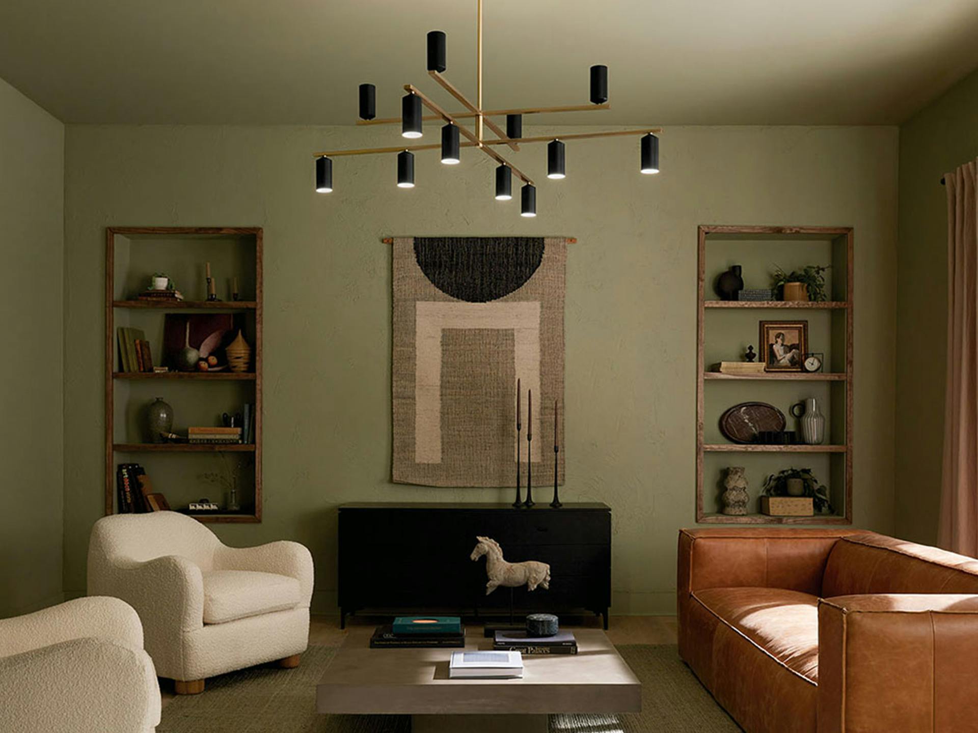 12 light Gala Chandelier hanging over the coffee table of a green modern styled living room