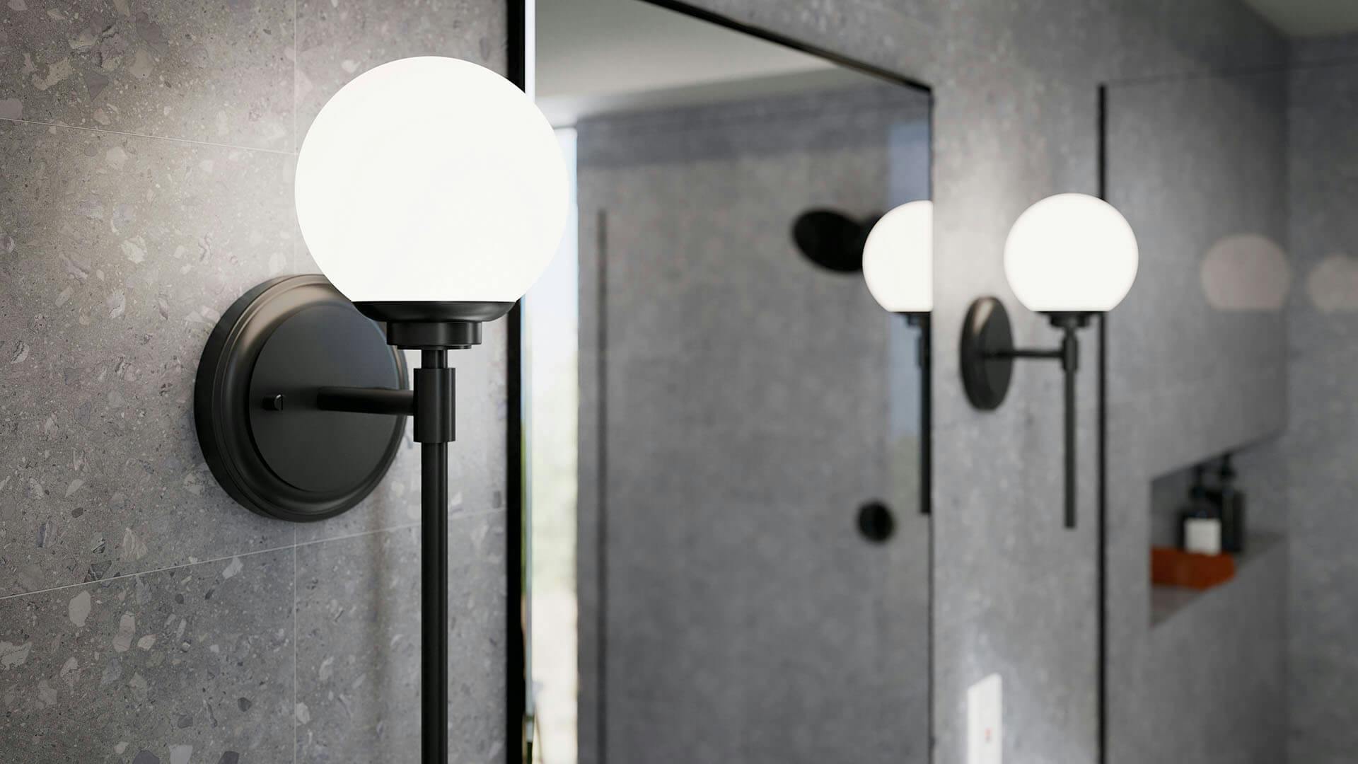 Two Benno sconces in black on either side of a rectangular mirror in a bathroom.