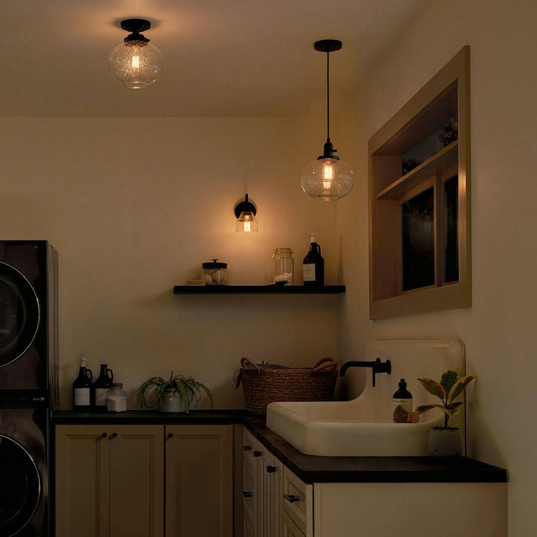 Laundry room at night with the Avery 11.25 Inch 1 Light Mini Pendant with Clear Seeded Glass in Black