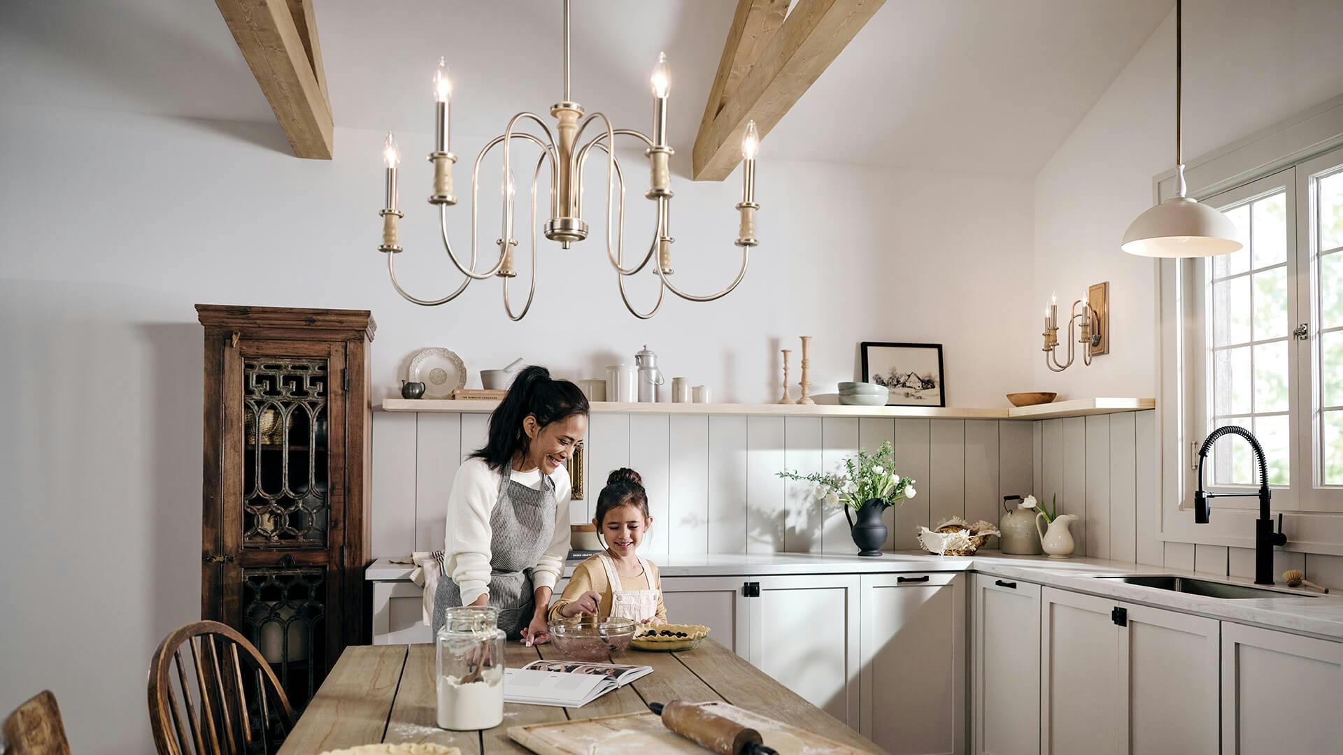 Mom and daughter baking in a rustic kitchen featuring a Karthe chandelier