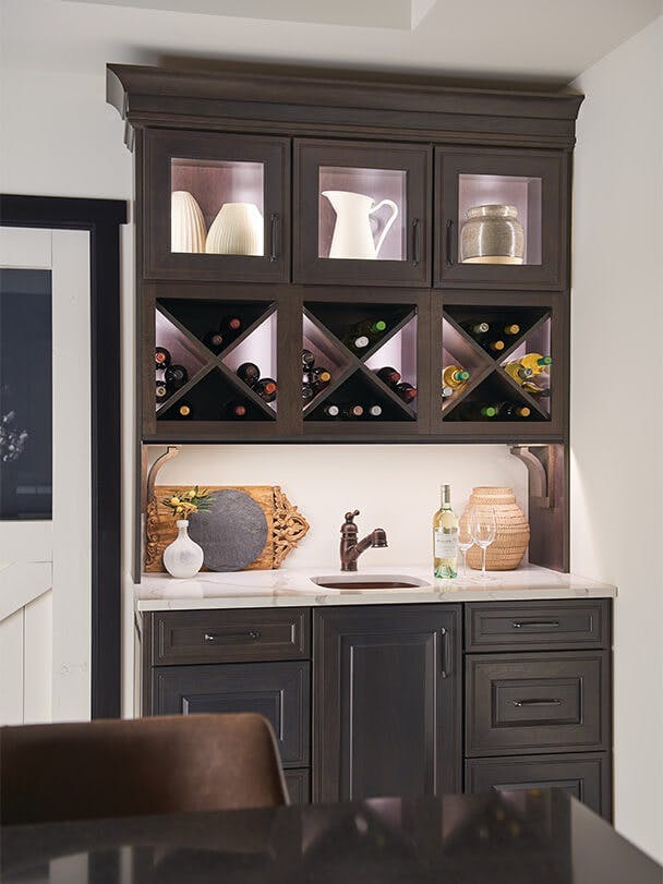 Cabinet nook filled with pottery and wine featuring downlighting