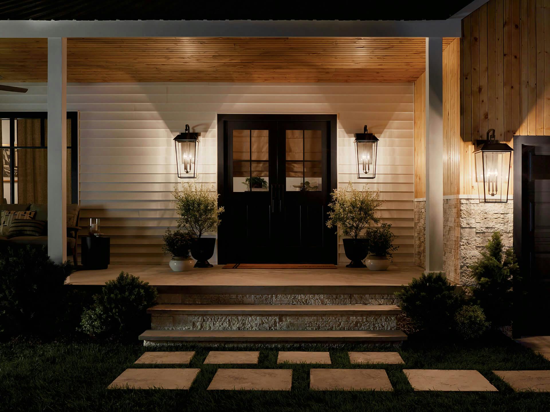 Front porch at dusk lit up by three Mathus sconces, one by the garage and two on each side of the door