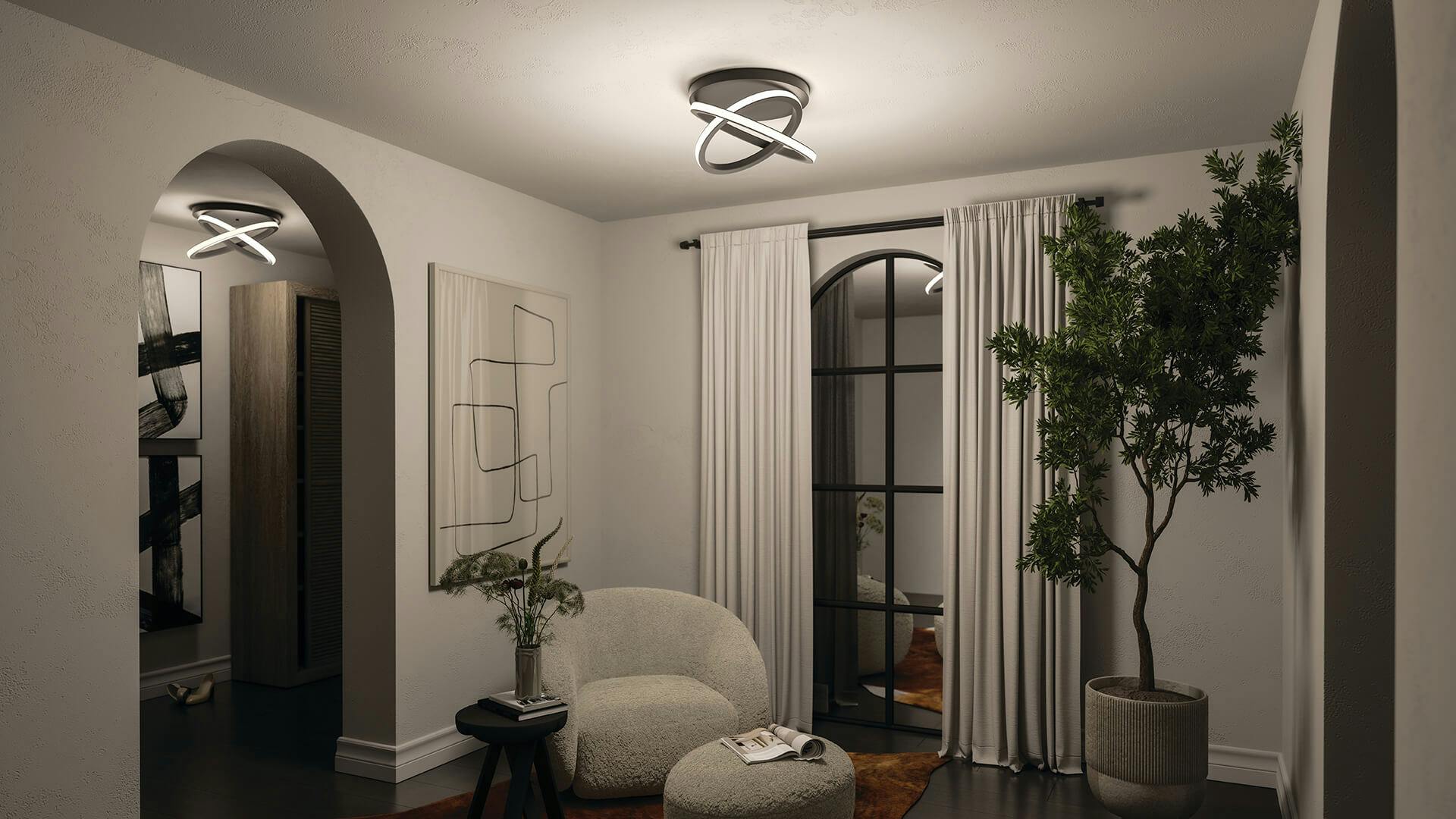Small living room corner at night with accent chair and ottoman featuring a Caputo ceiling light
