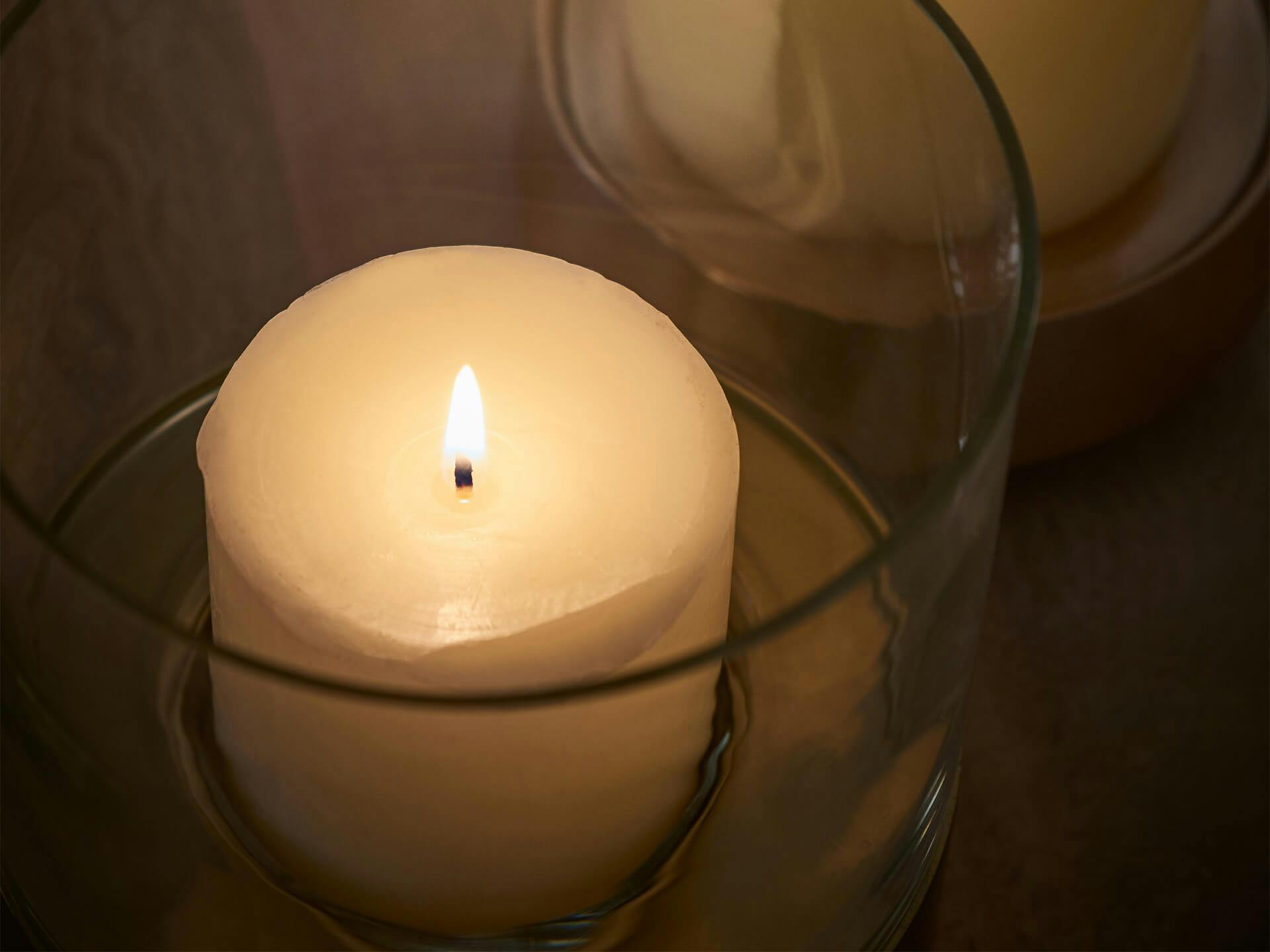 Overhead view of a burning candle in a glass holder