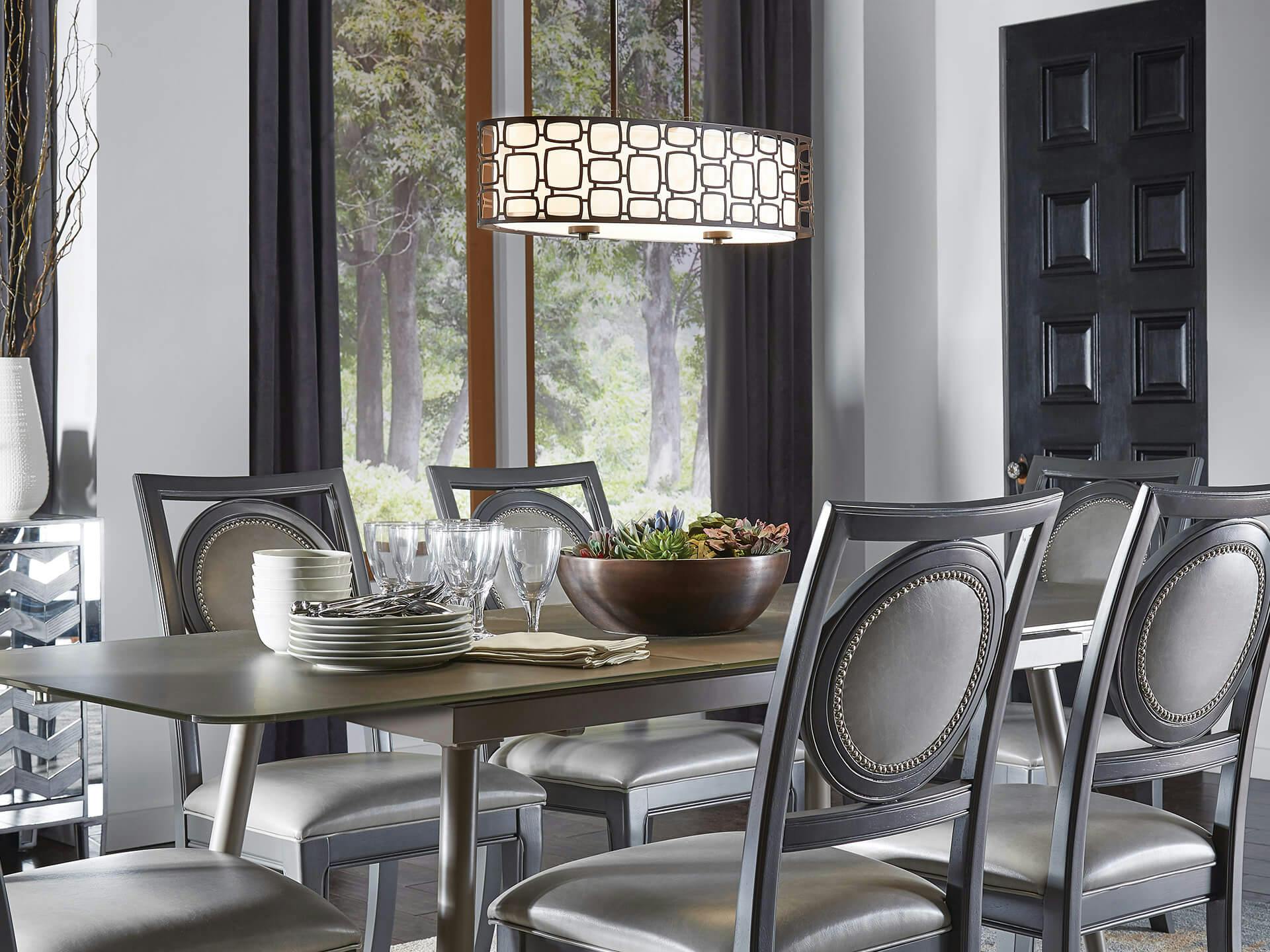 Dining room during the day with gray chairs and a Sabine chandelier hanging above the table