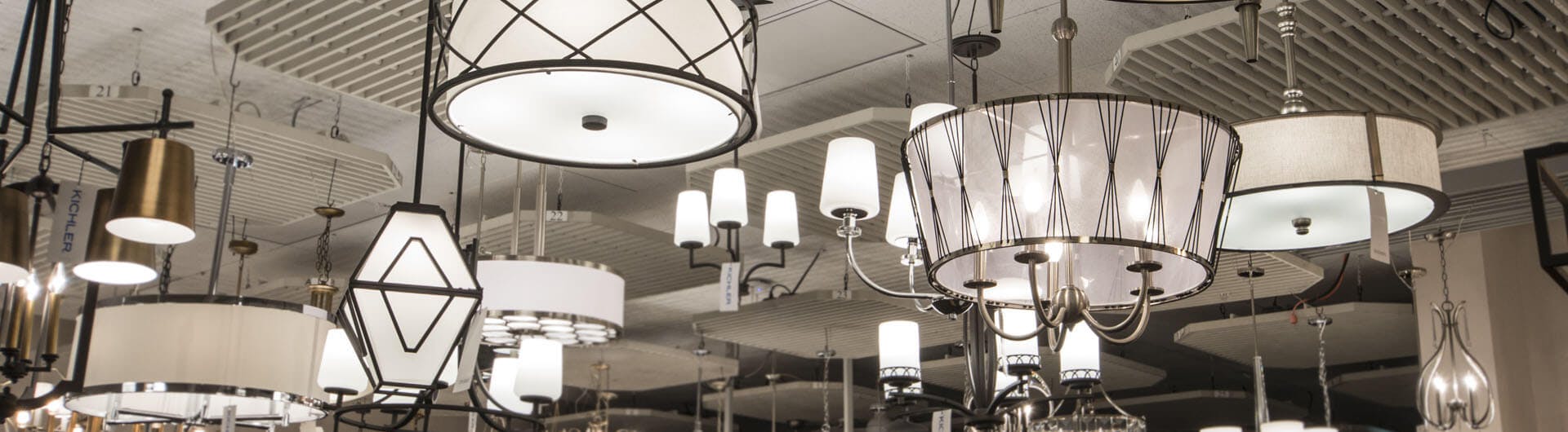 Variety of chandeliers hanging from a showroom ceiling