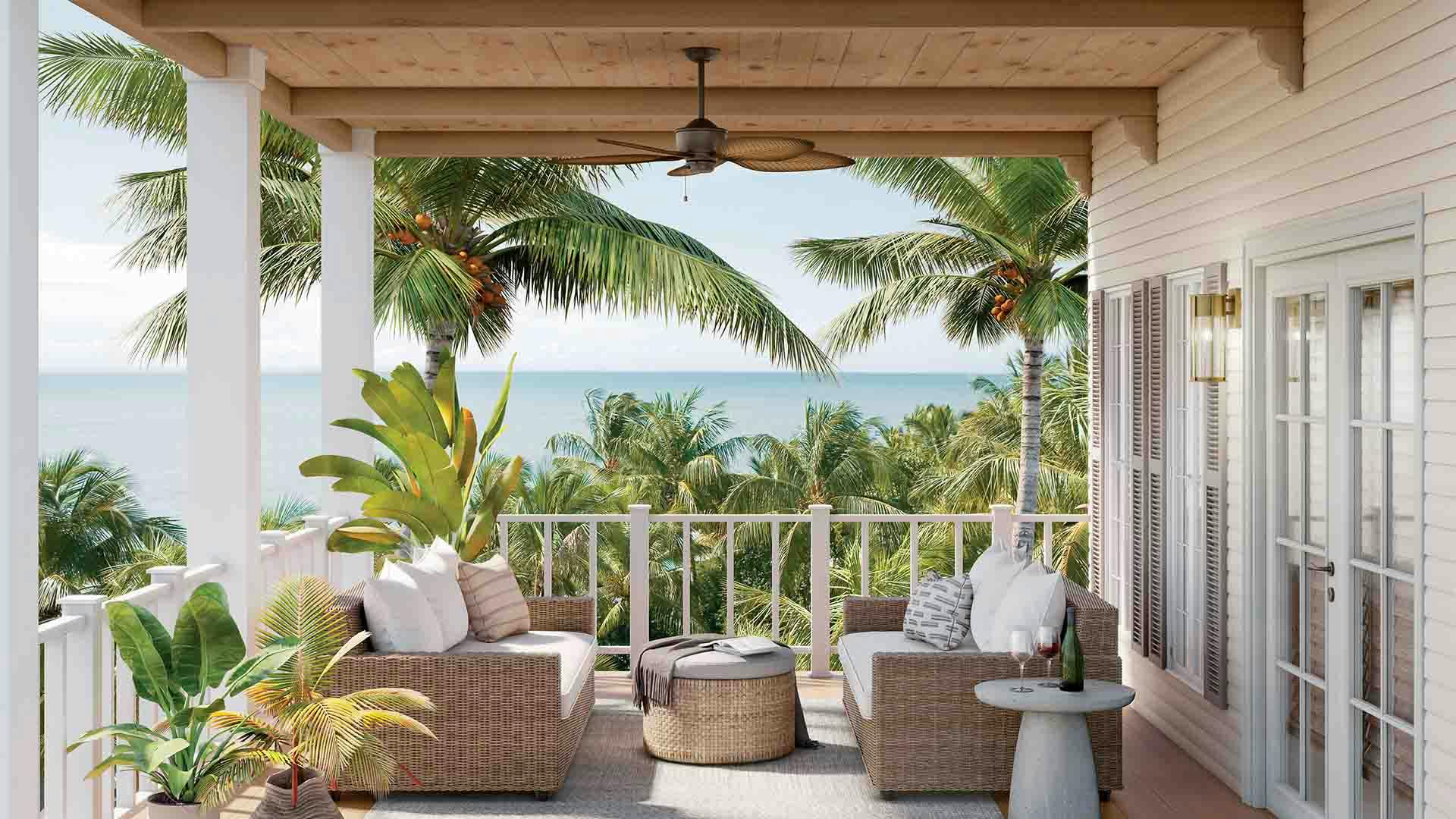 Nani ceiling fan in satin natural bronze on patio with ocean and palm trees in the background.