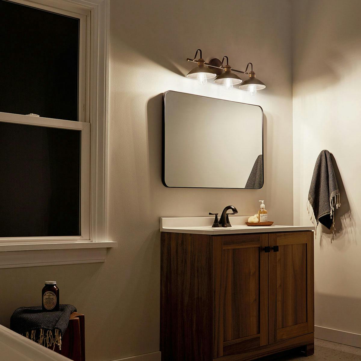 Night time Bathroom featuring Clyde vanity light 45945OZ