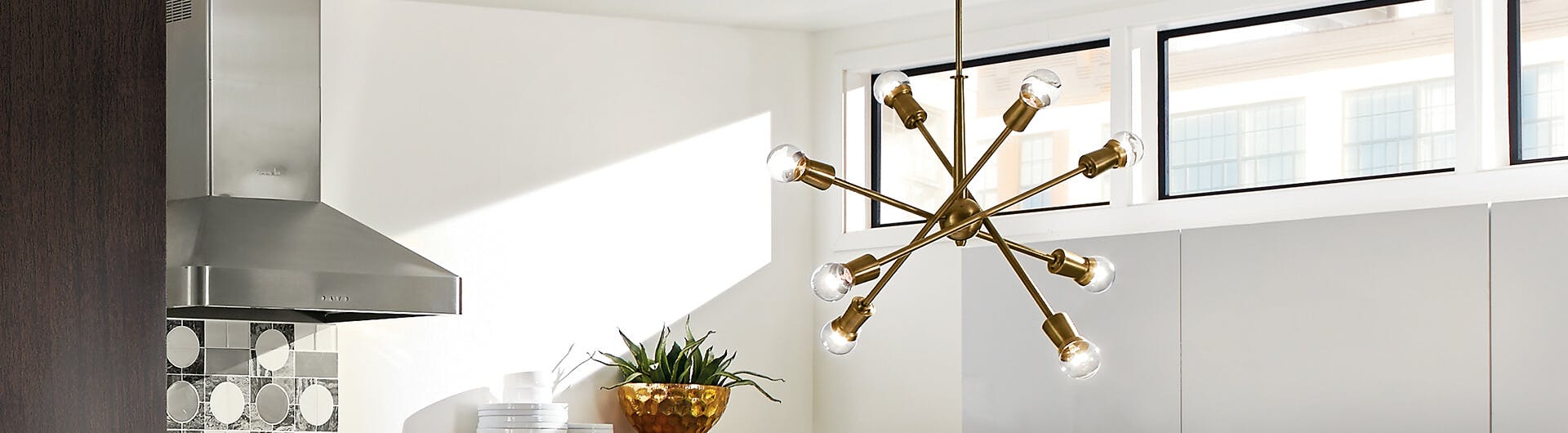 Gold finish Armstrong chandelier hanging in a modern white kitchen