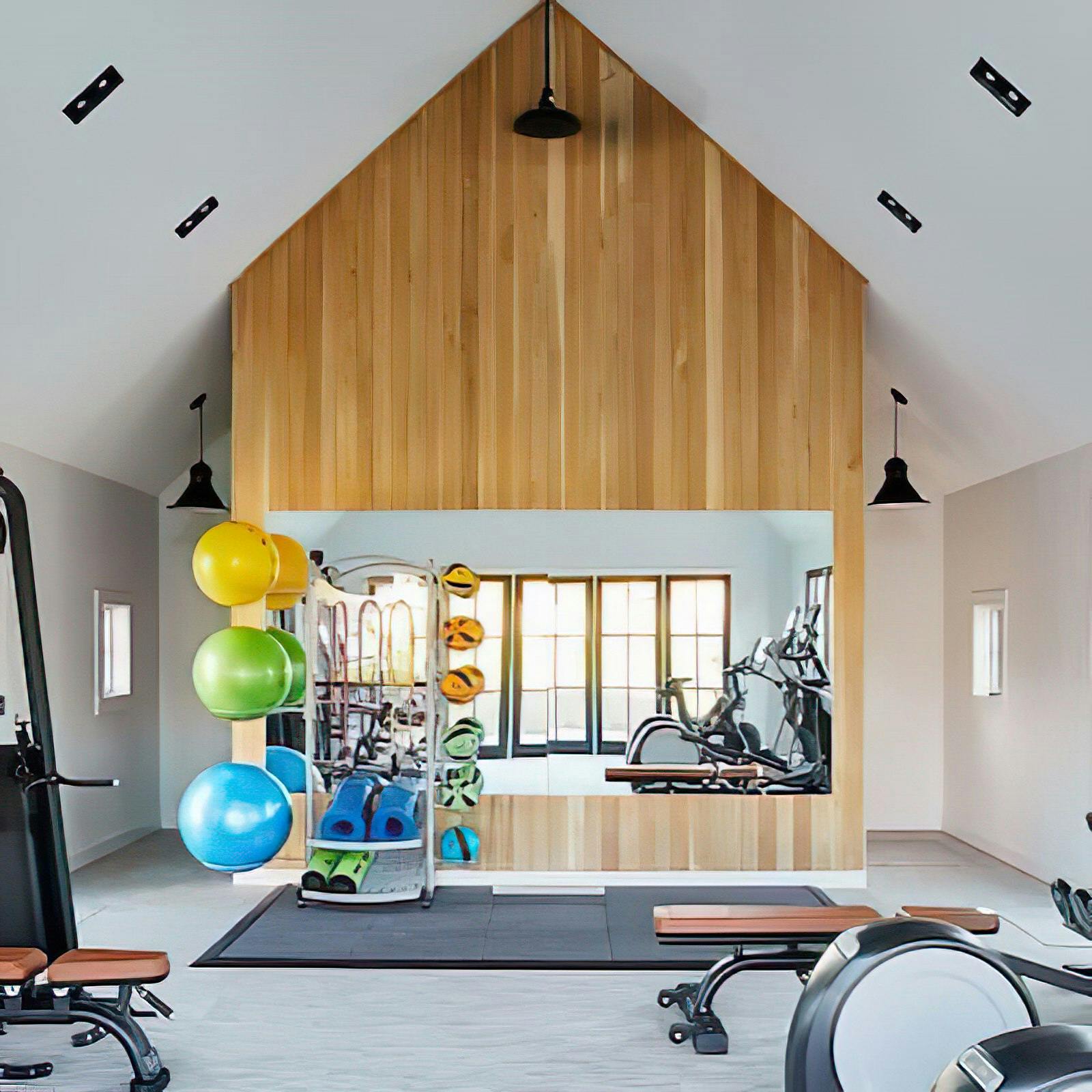 Home gym with A-frame ceiling with variety of work out equipment
