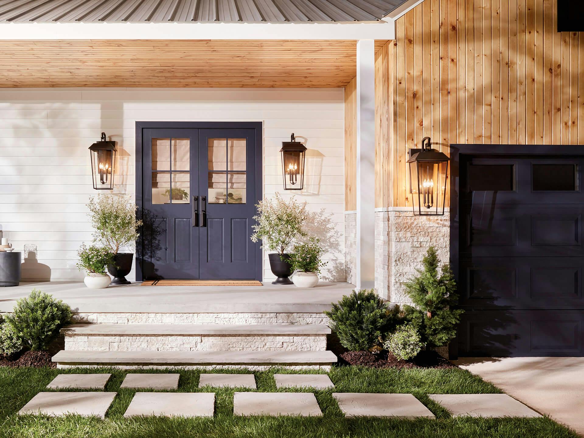 A wideshot of a porch and garage featuring Mathus sconces during the day