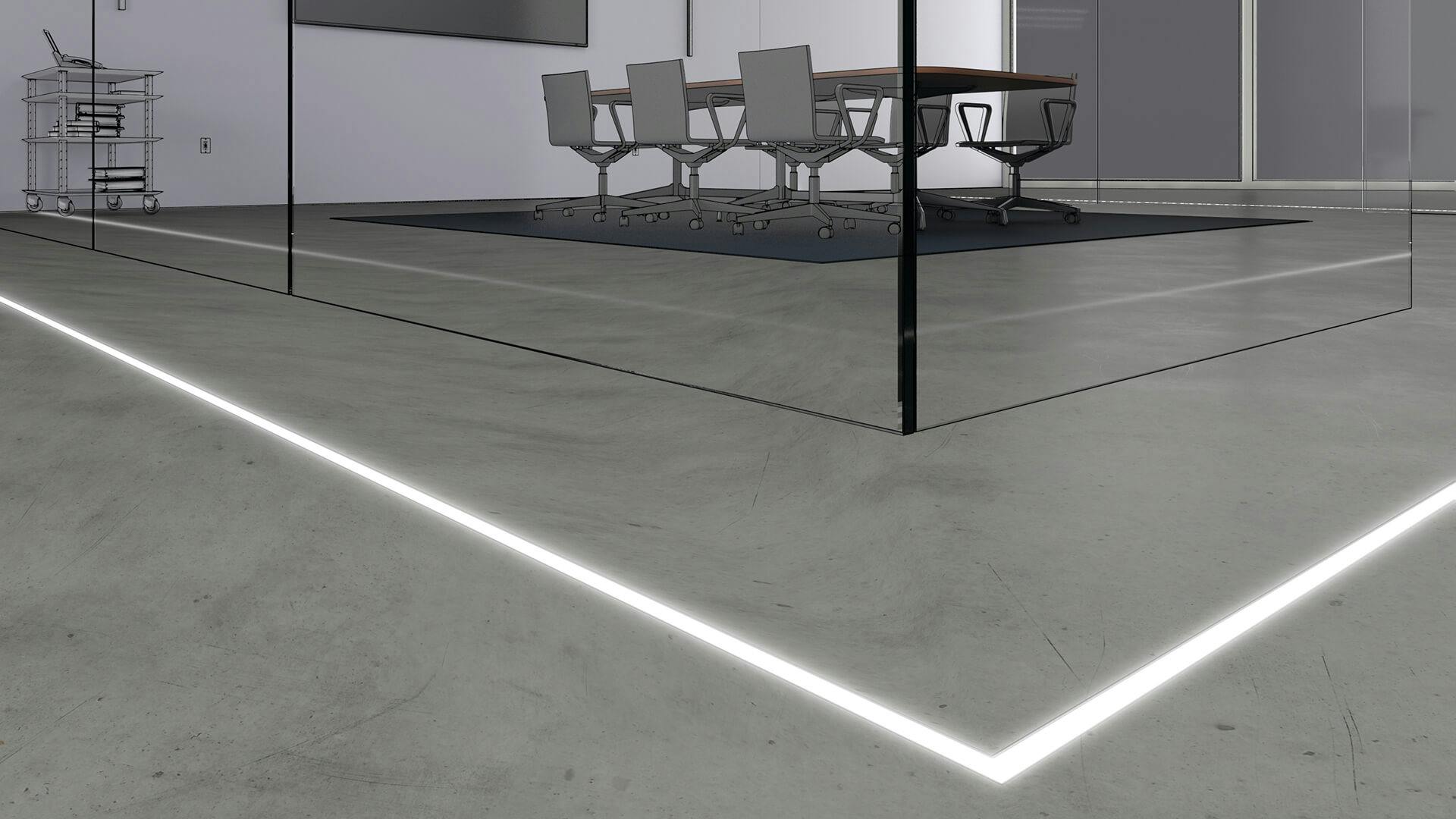 Close up of an office's cement floor with channel lighting lining a conference room.