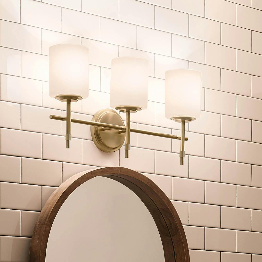 Night time bathroom with Ali 11.5" 3 Light Vanity Brushed Natural Brass