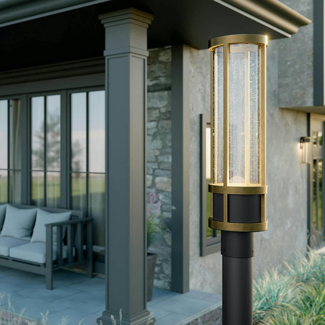 Stone exterior with the Camillo 20" LED Outdoor Wall Light with Clear Seeded Glass in Textured Black with Natural Brass