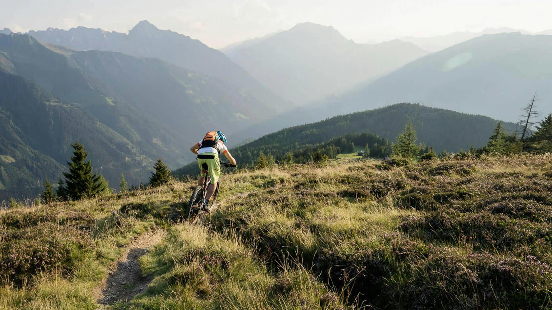 A person riding their bike across a grassy mountain range