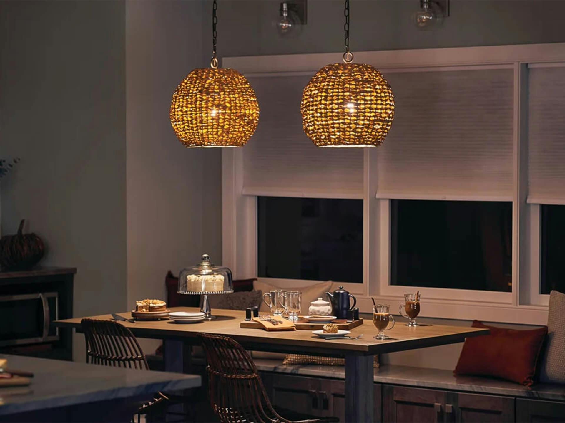 Two Palisades pendant lights hanging over a warmly lit dining room table