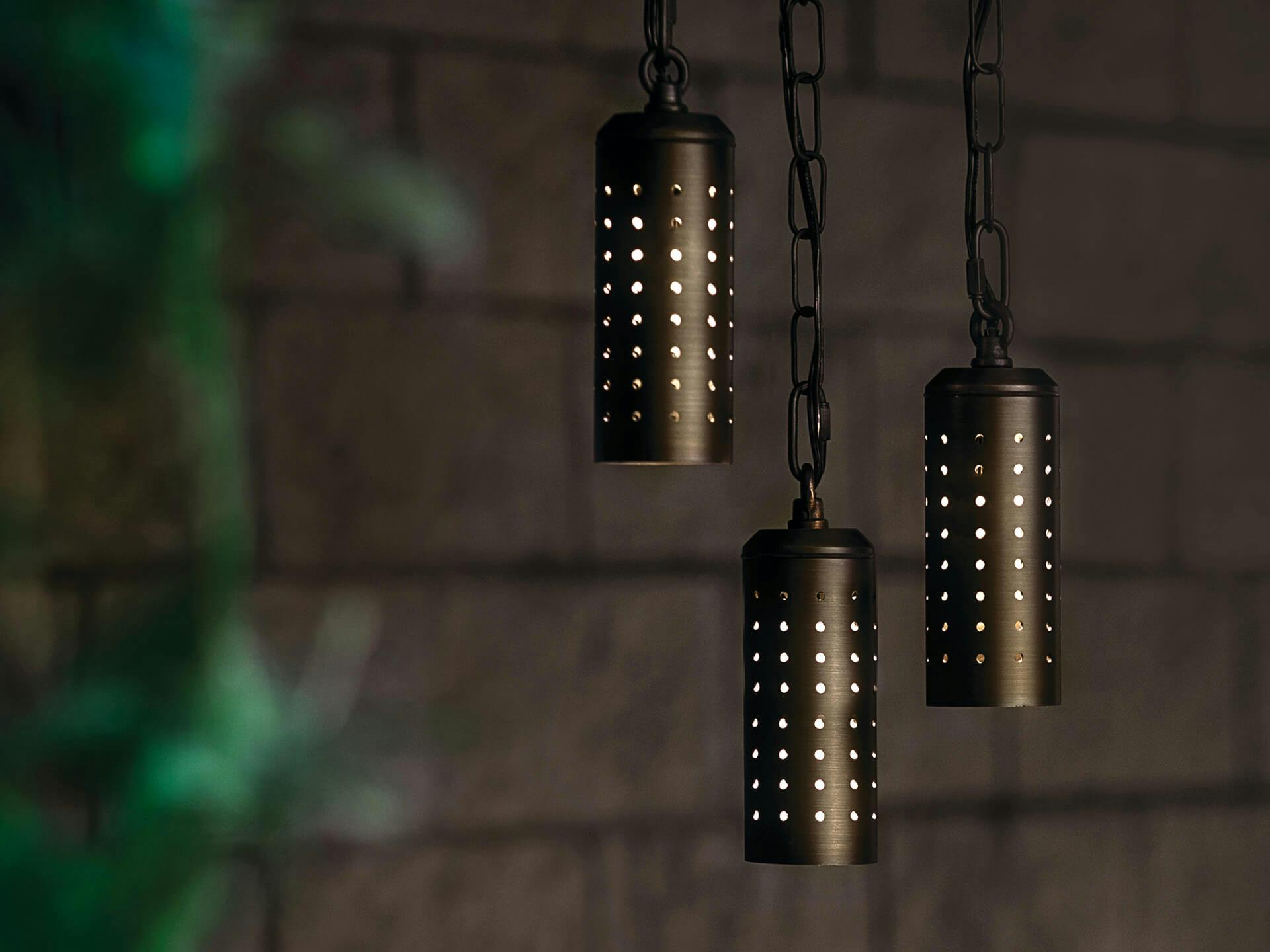 Three pendant lamps in brass finish at night
