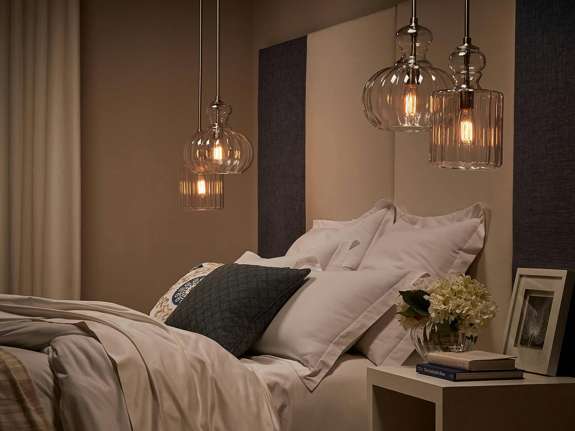 A bed surrounded by Riviera hanging lights in a dimly lit bedroom at night