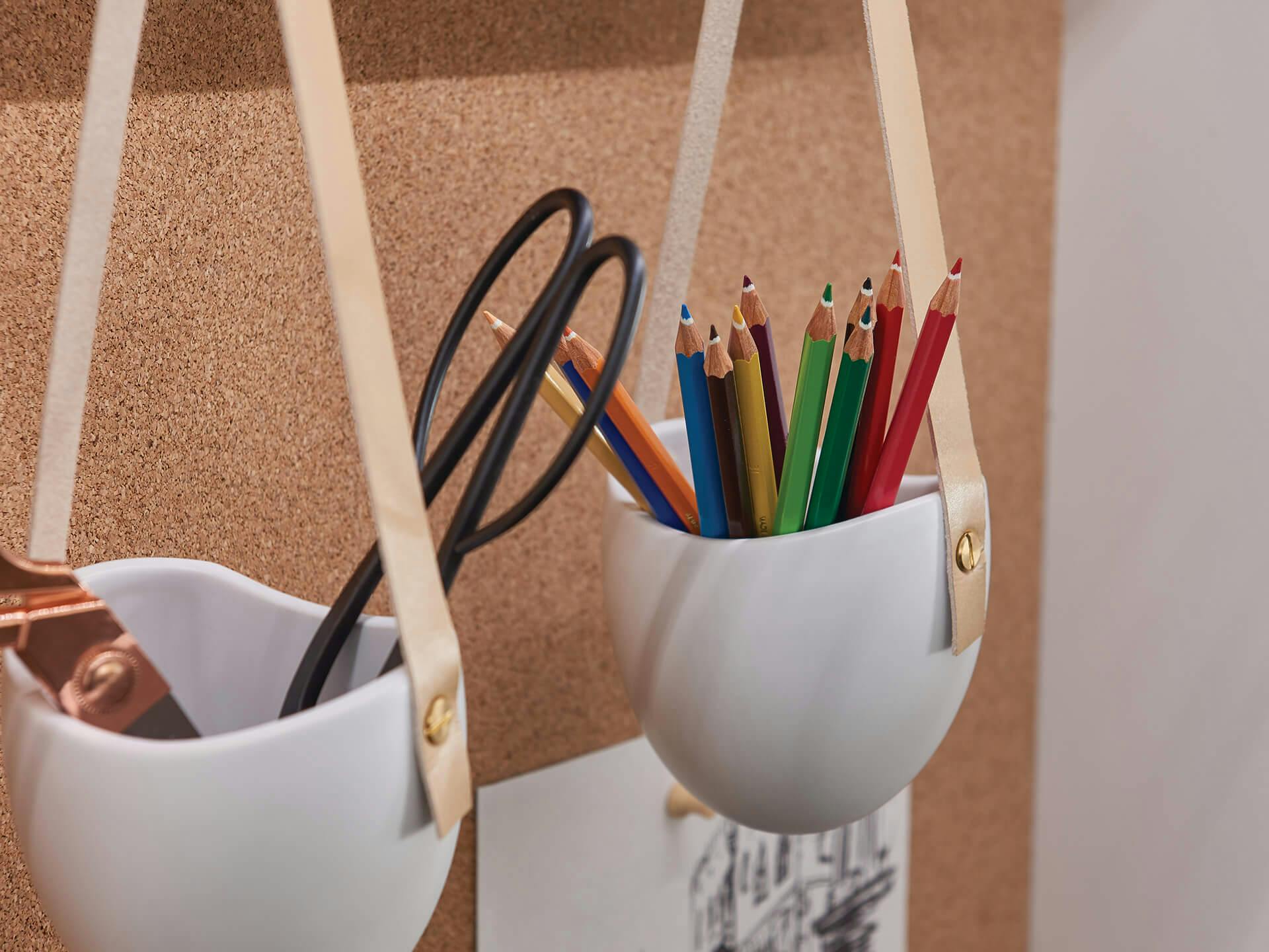 Desk organizers holding colored pencils and scissors