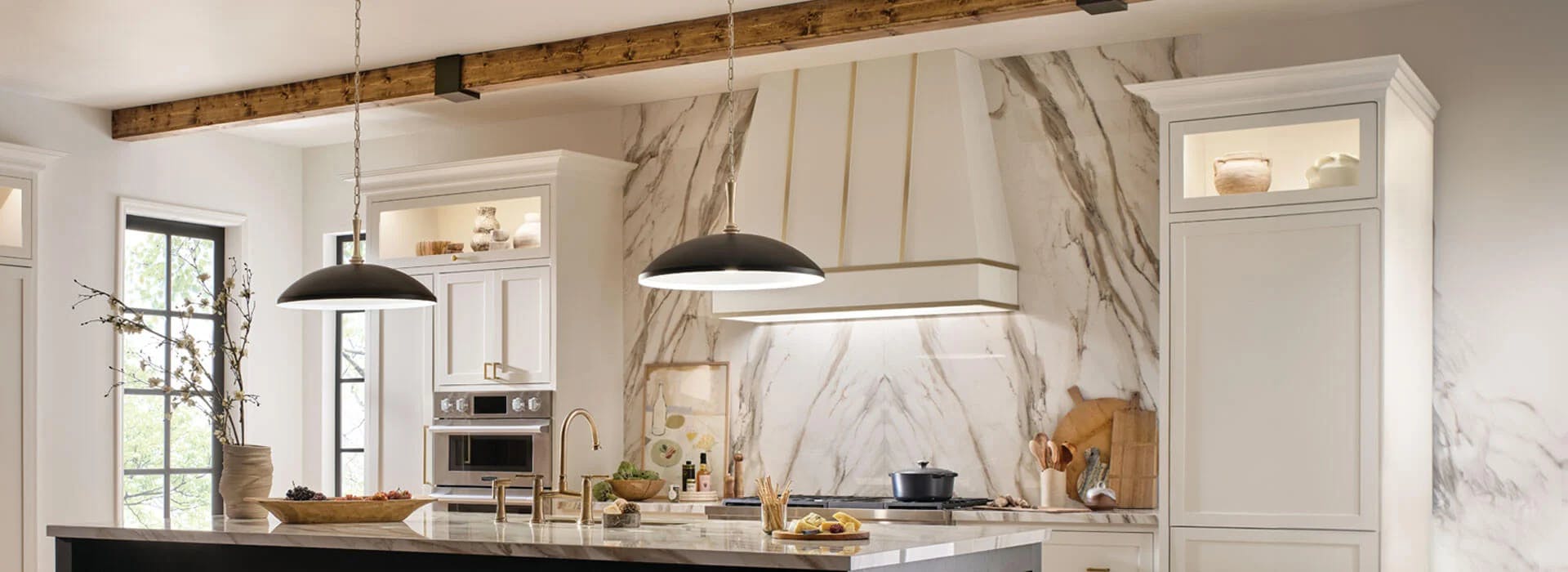 A modern kitchen with marble accents featuring two delarosa pendant lights over a kitchen island.