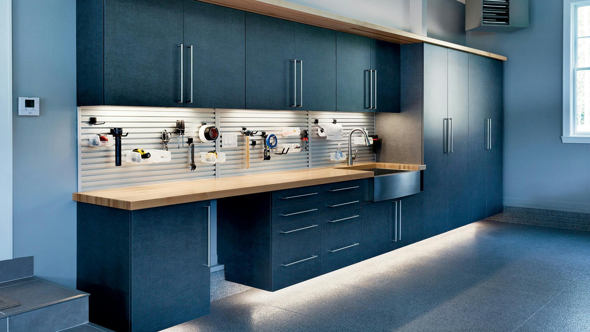 All blue modern garage cabinetry and work bench, blue walls and blue cabinets with tape lighting