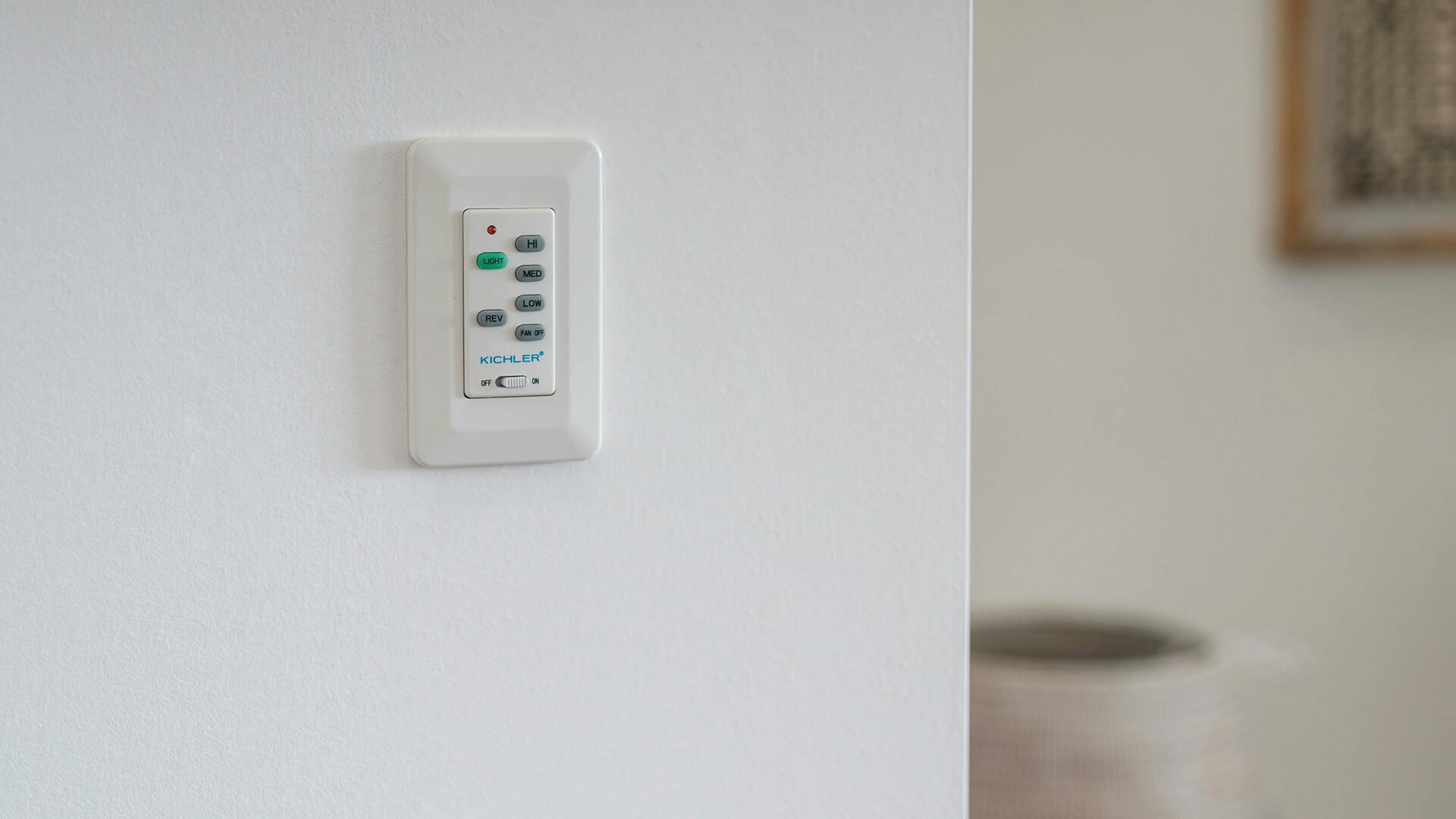 Fan and light control panel on a white wall