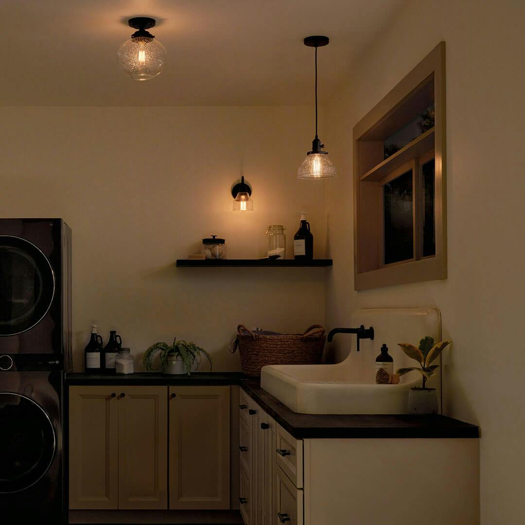 Laundry room at night with the Avery 8.5 Inch 1 Light Bell Mini Pendant with Clear Seeded Glass in Black