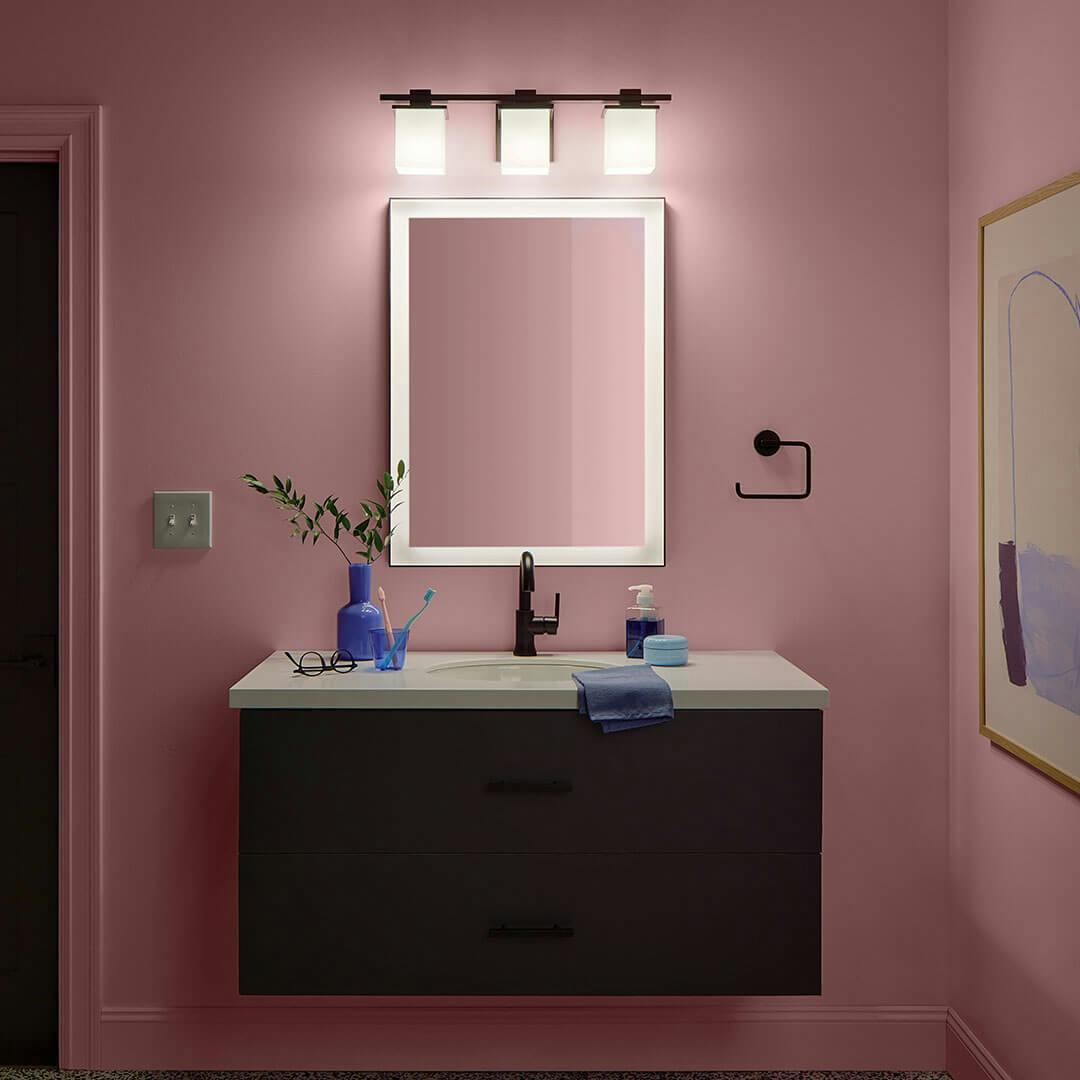 Bathroom at night with the Tully 24" 3-Light Vanity Light in Black