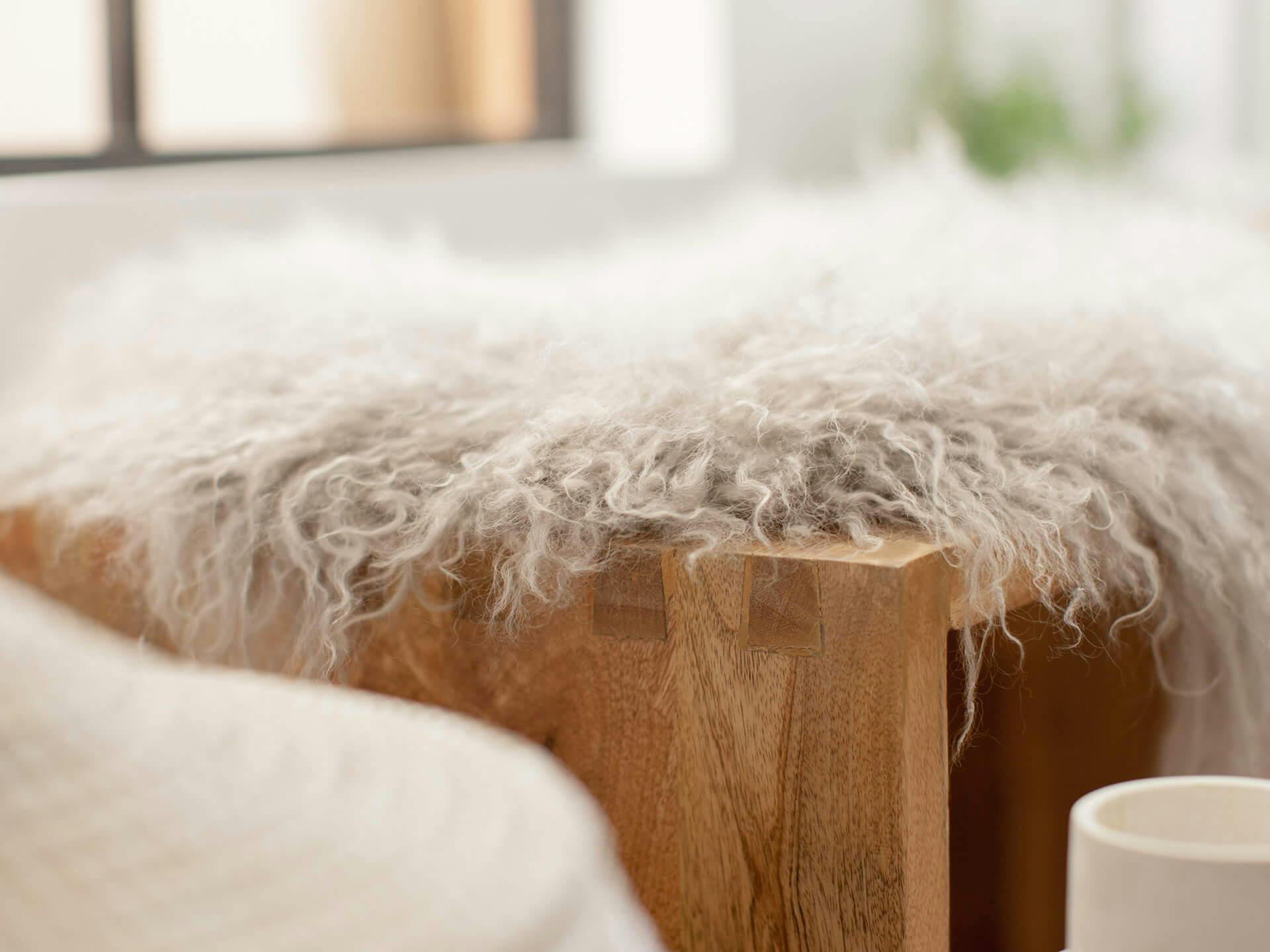 Close up of a fuzzy blanket on a wood bench