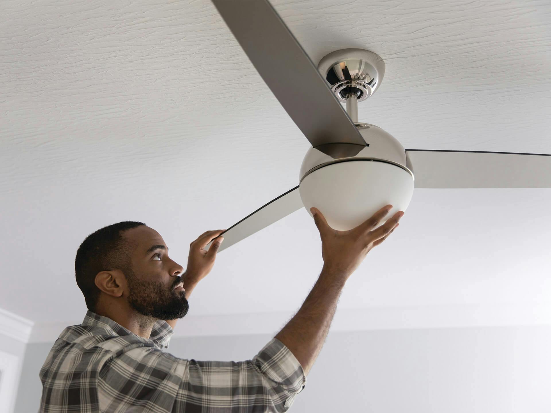 Man inspecting a ceiling fan