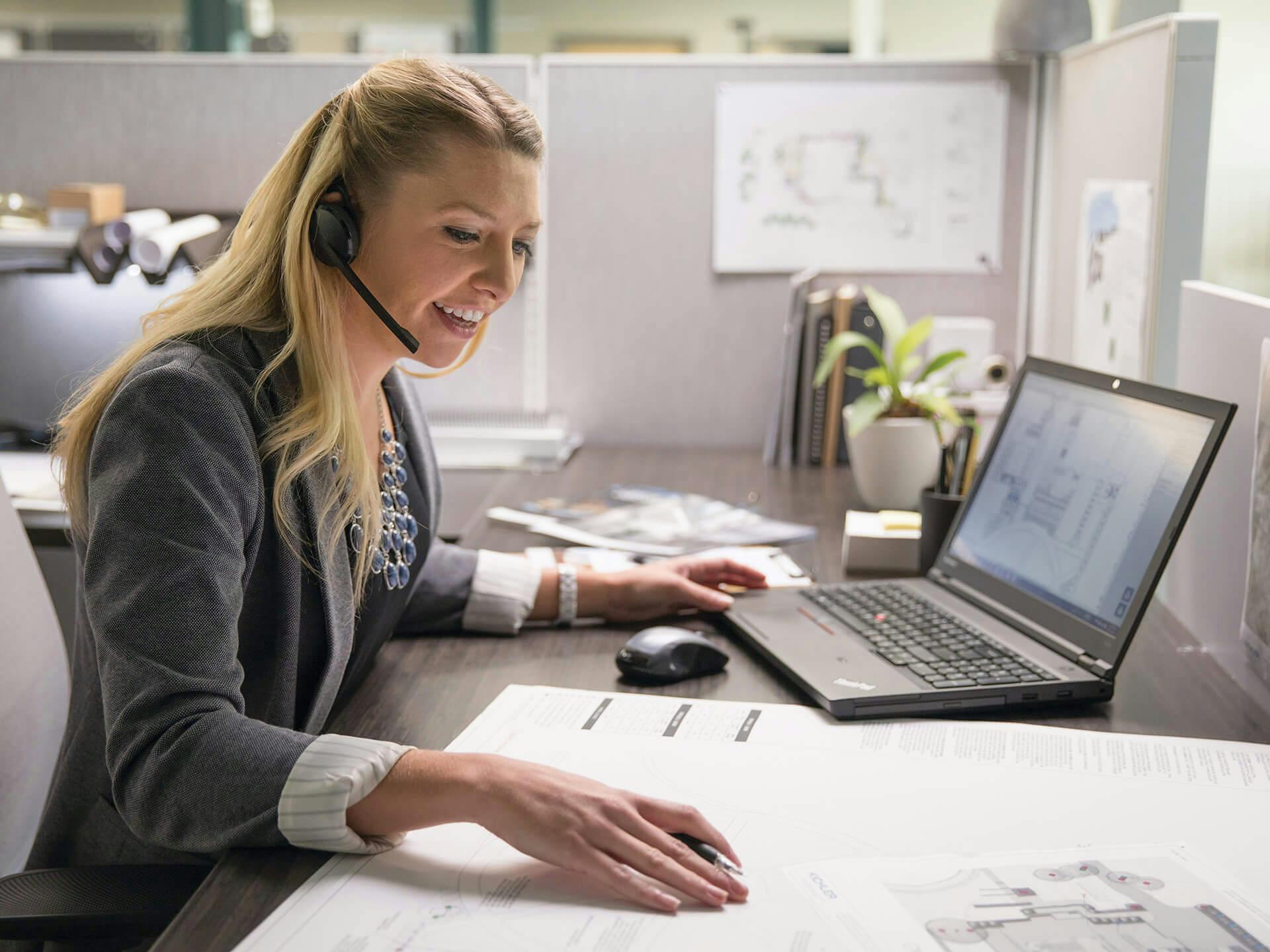 Customer service worker sitting at a desk wearing a headset