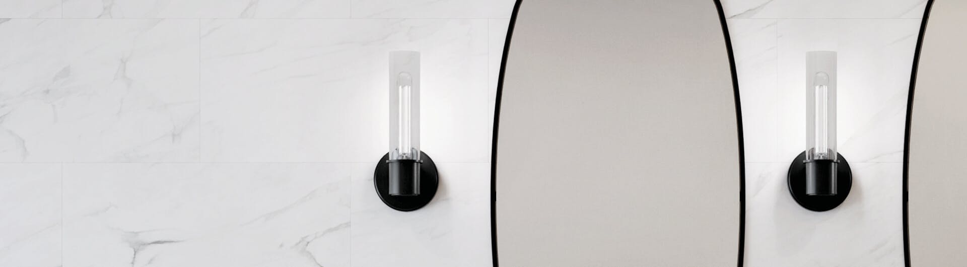 Closeup of bathroom mirror with two black Aviv sconces lit on each side