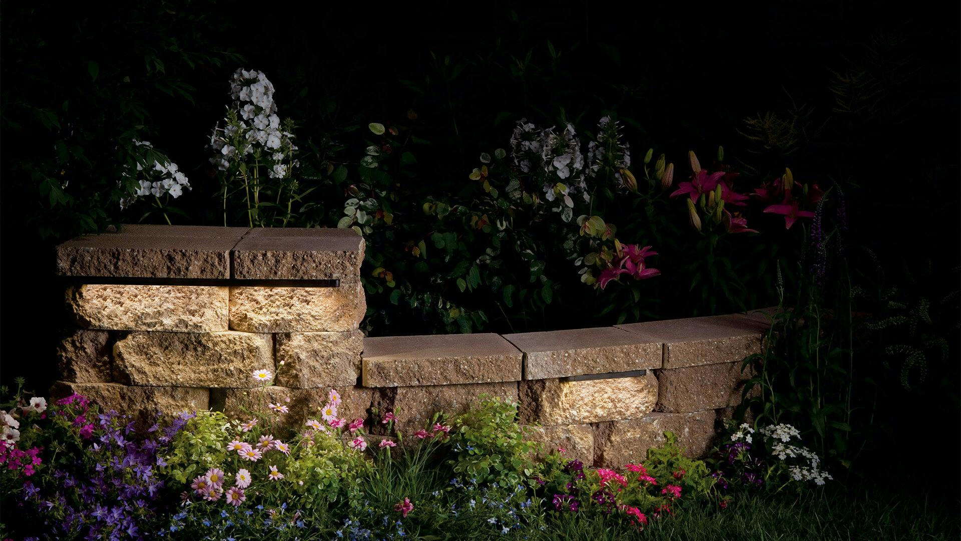 Dark landscape at night, close up of a lit stone garden bed
