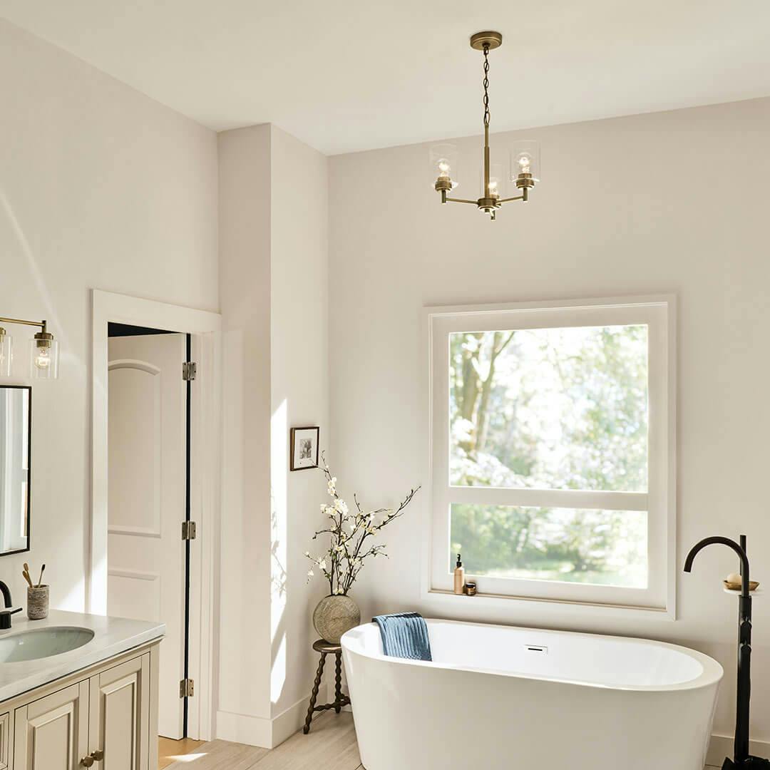 Bathroom in day light with the Winslow 15.5" 3-Light Chandelier in Natural Brass