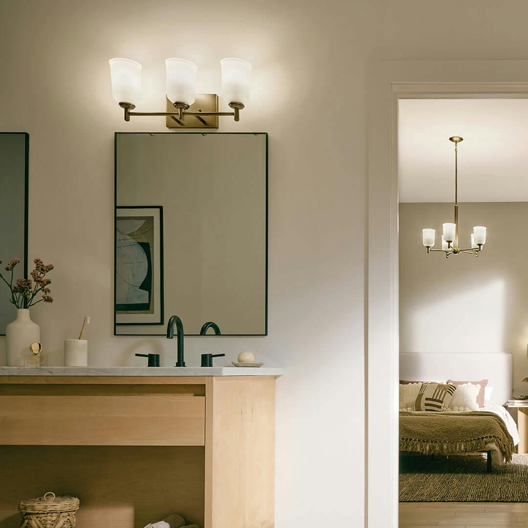 Bedroom in day light with the Shailene 21" 3-Light Vanity Light in Natural Brass