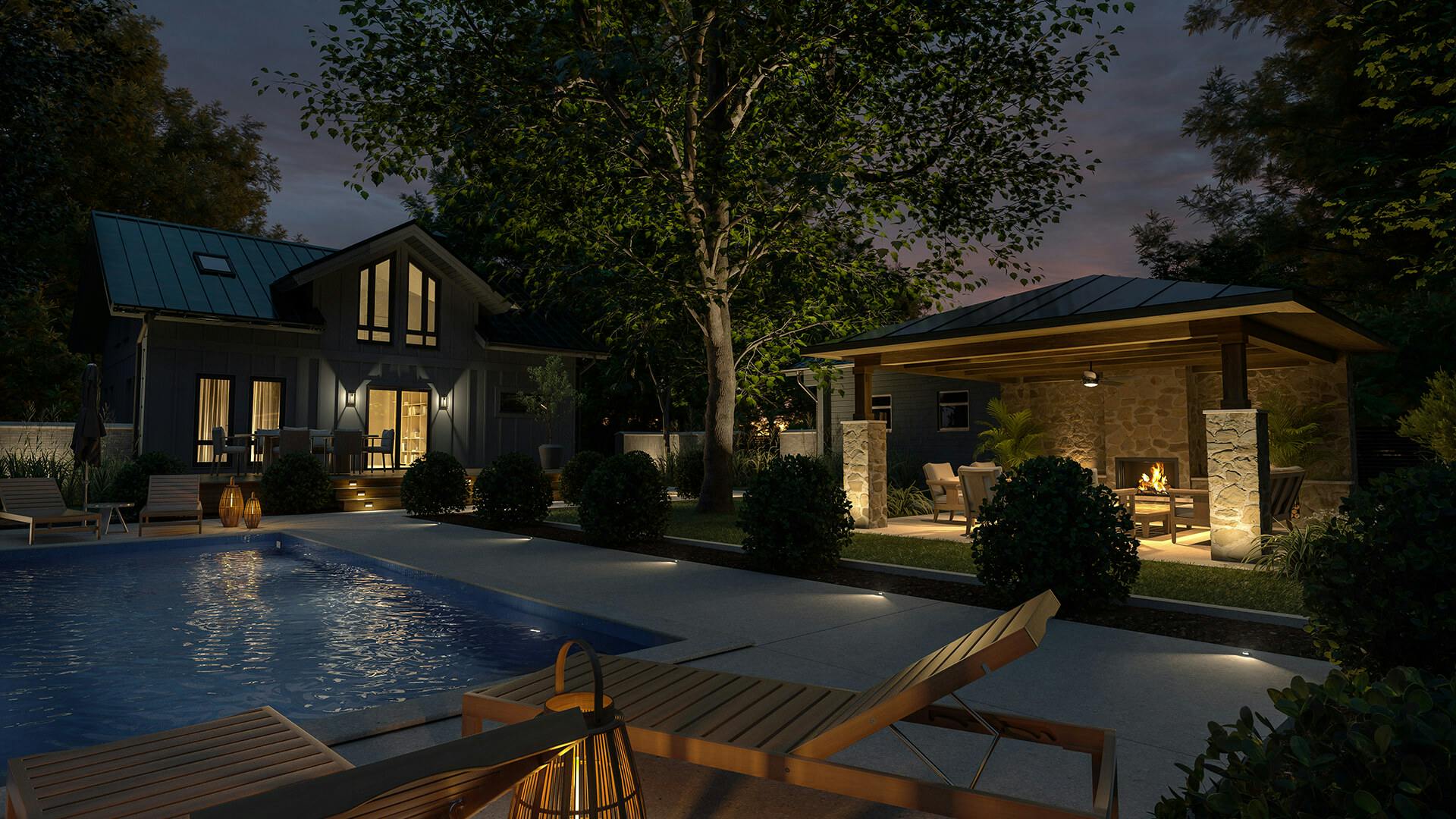 Exterior of a pool house and outdoor patio at night with variety of lighting on the buildings, pathways and trees