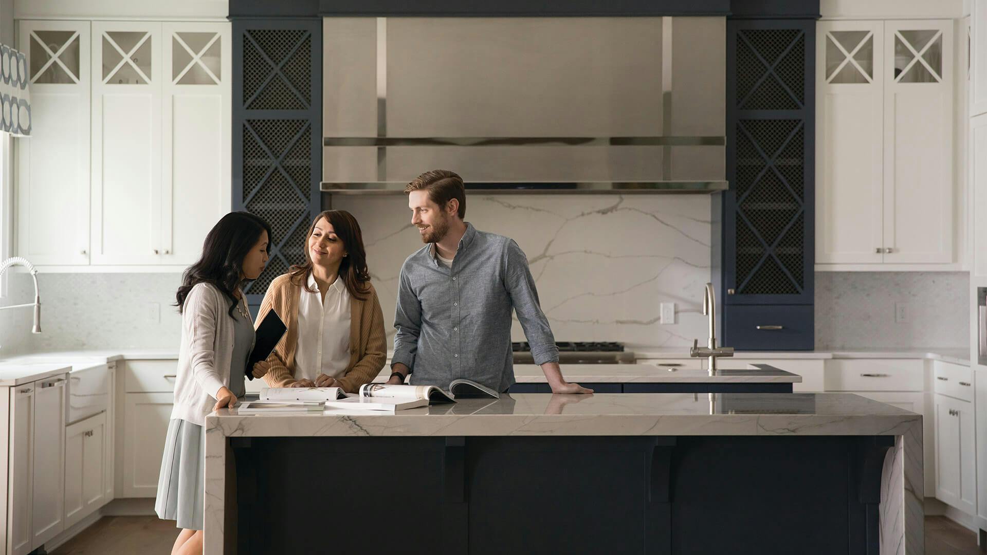 Kichler consultant assisting a smiling man and woman in their kitchen