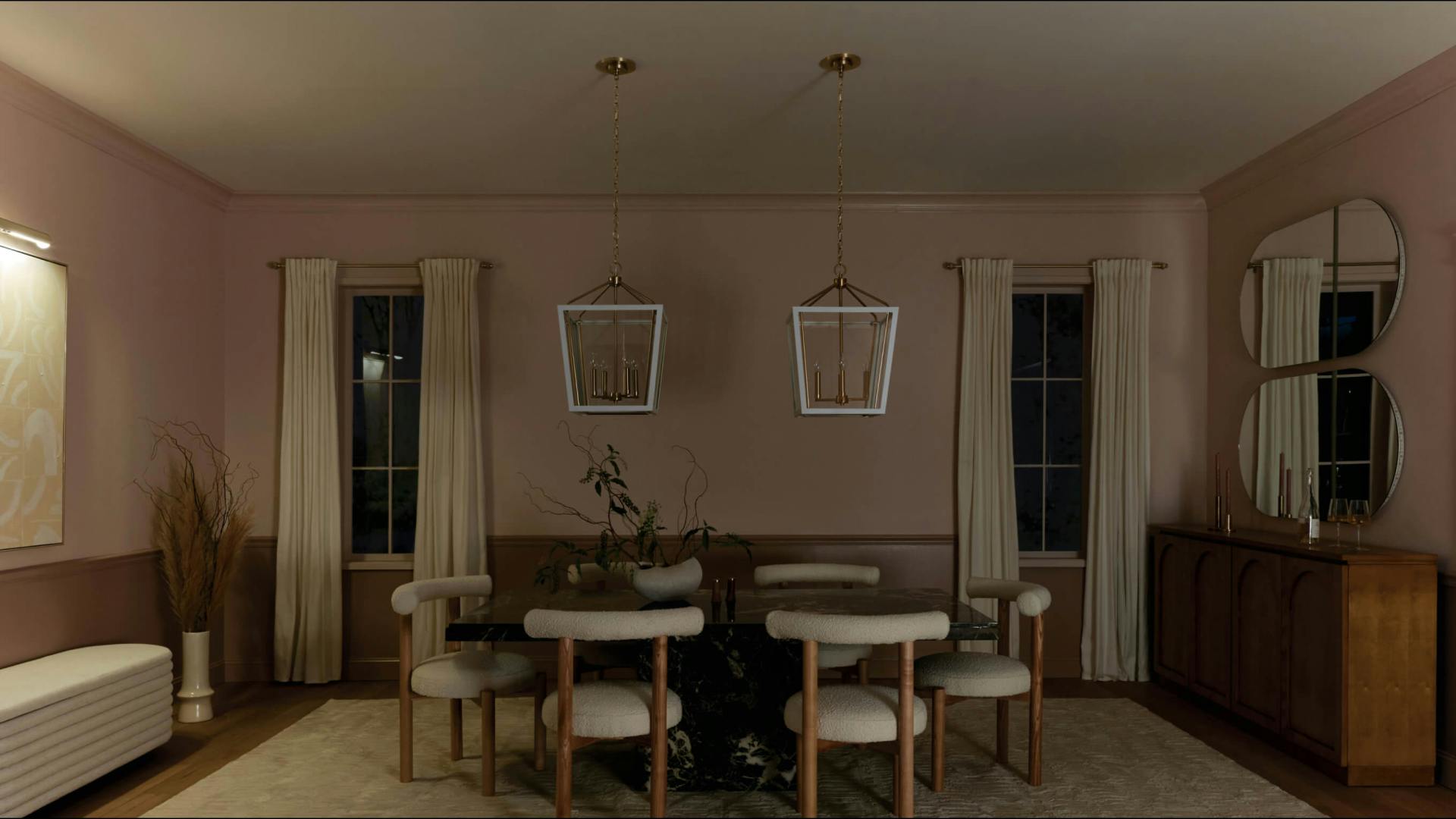Dinning room with all lights turned off besides the Midi sconce on the left wall lighting up a painting at night 