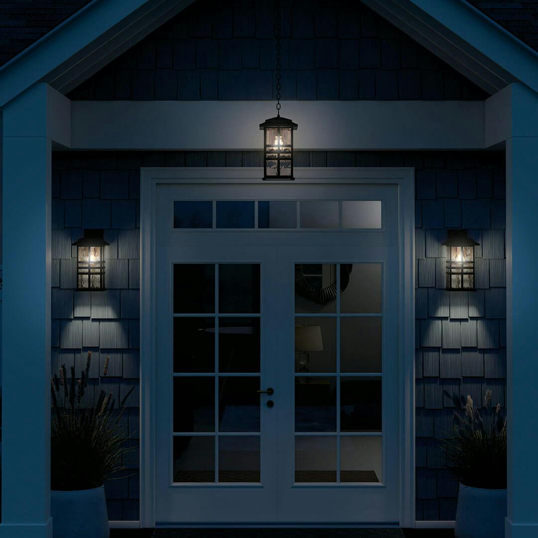 Night time view of the Beacon Square 17.5" 1-Light Outdoor Wall Light in Textured Black on the porch of a home