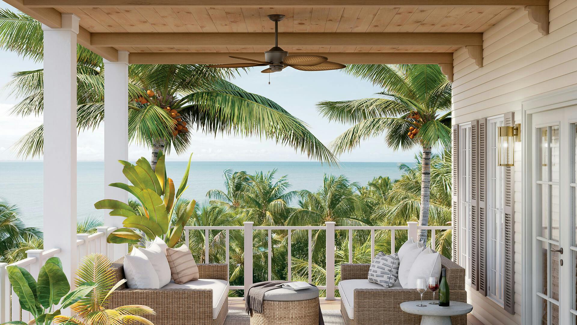 Costal porch with palm trees and ocean in the backdrop featuring a Nani ceiling fan