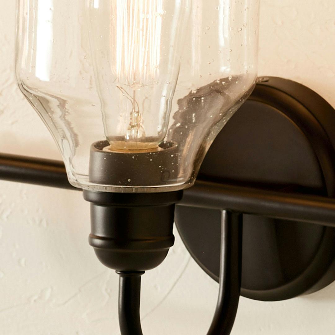 Close up of the Avery 24 Inch 3 Light Vanity Light with Clear Seeded Glass in Black