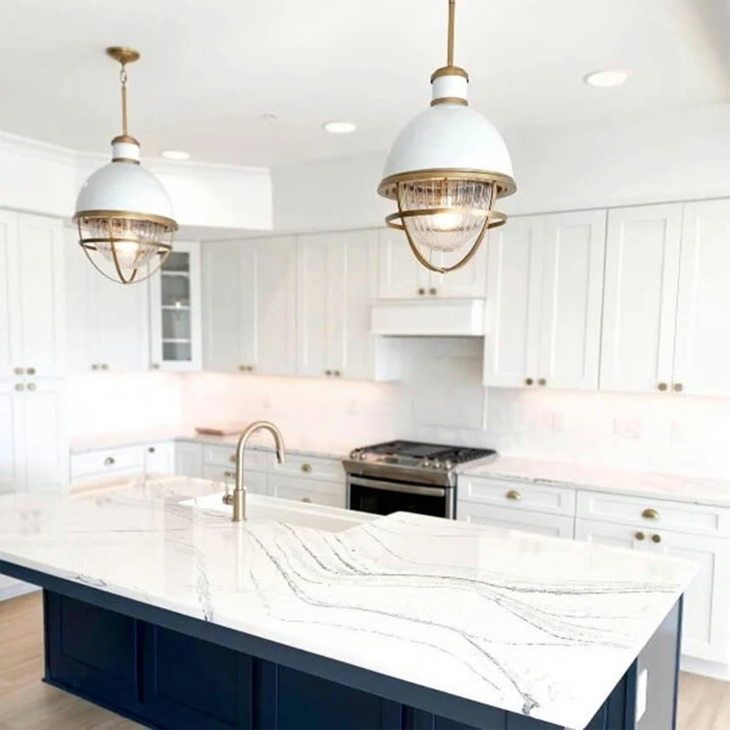 ginadragodesign instagram post of two Tollis pendants with white finish above a white marble kitchen island turned on during the day