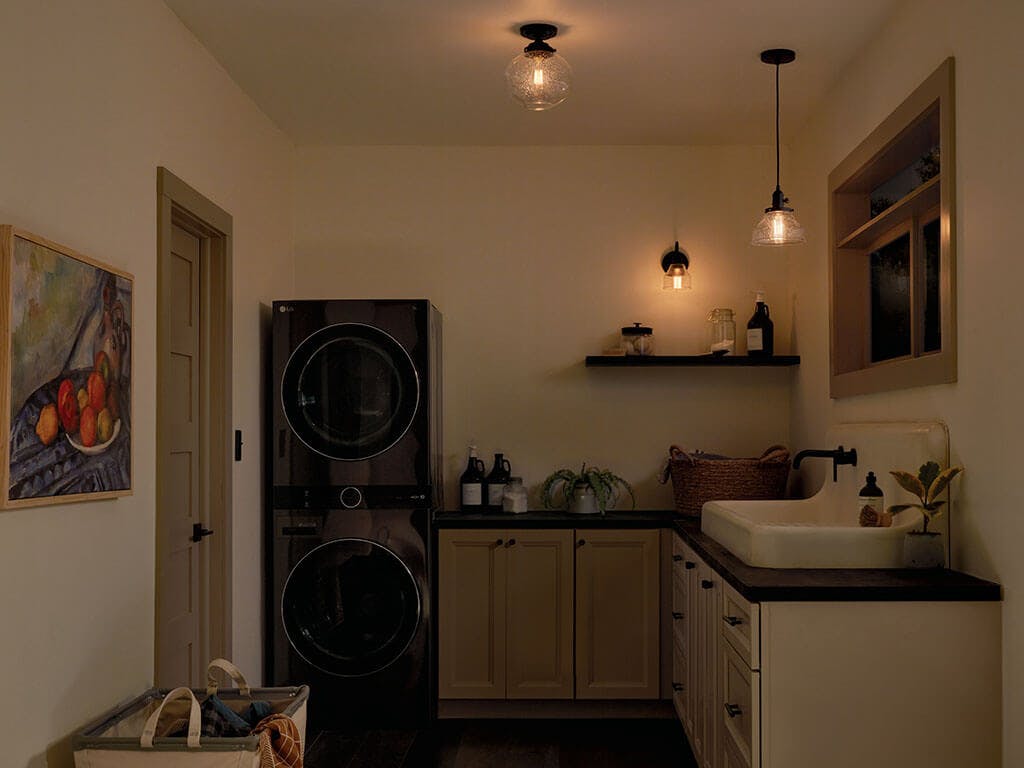 Laundry room at night with the Avery 8.5 Inch 1 Light Bell Mini Pendant with Clear Seeded Glass in Black