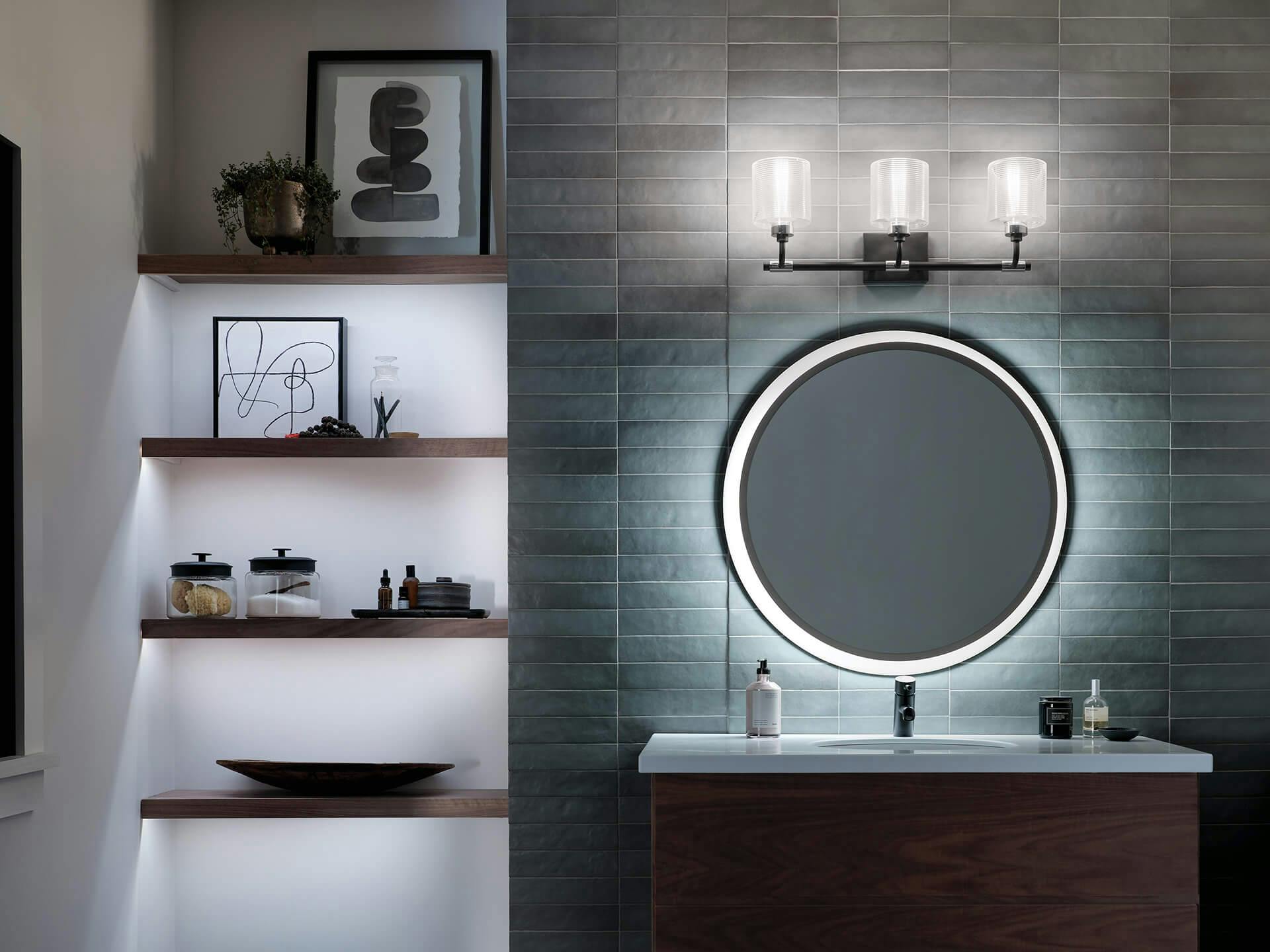 Modern bathroom at night with round LED mirror and Harvan sconce above the mirror