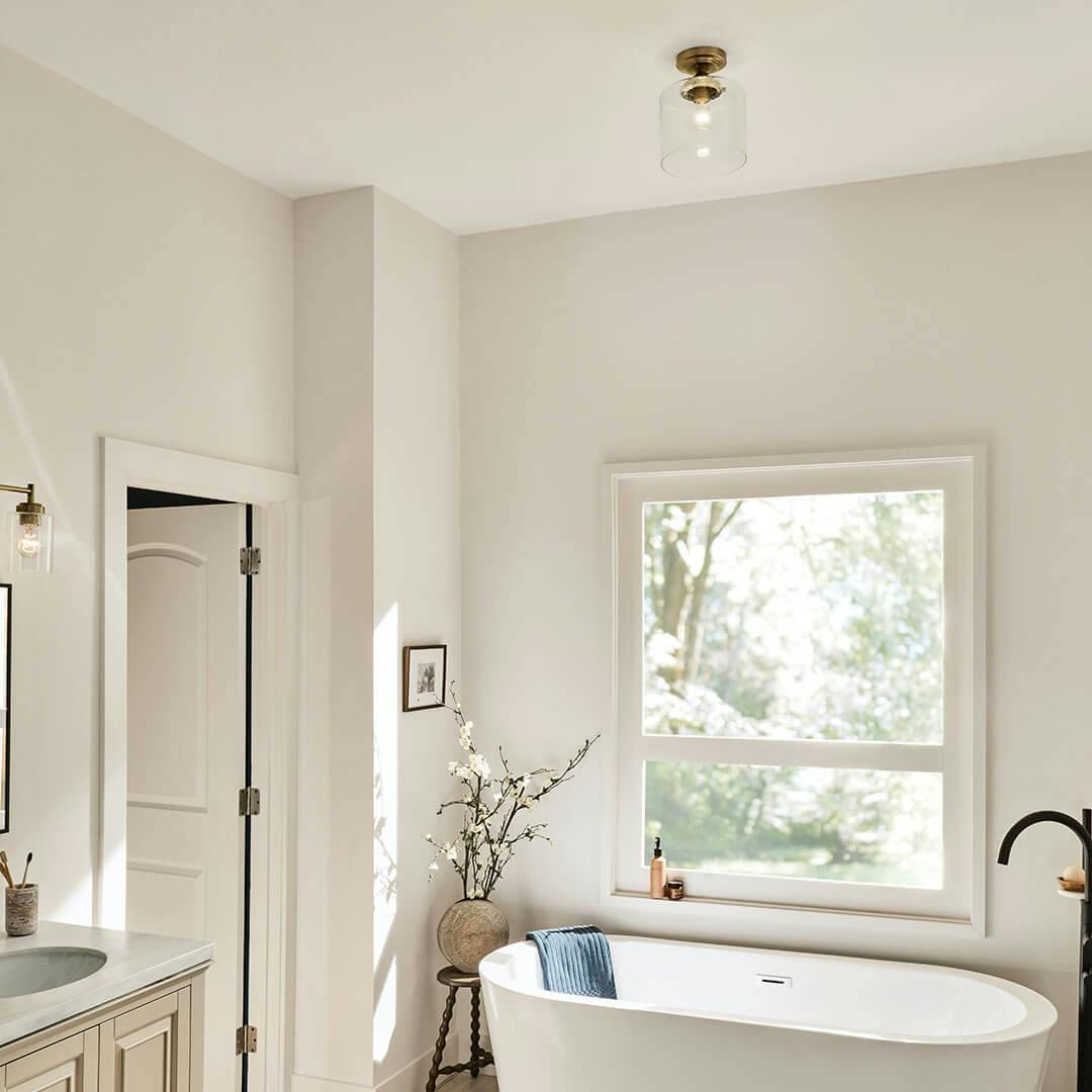 Bathroom in day light with the Winslow 10.75" 1-Light Semi Flush in Natural Brass