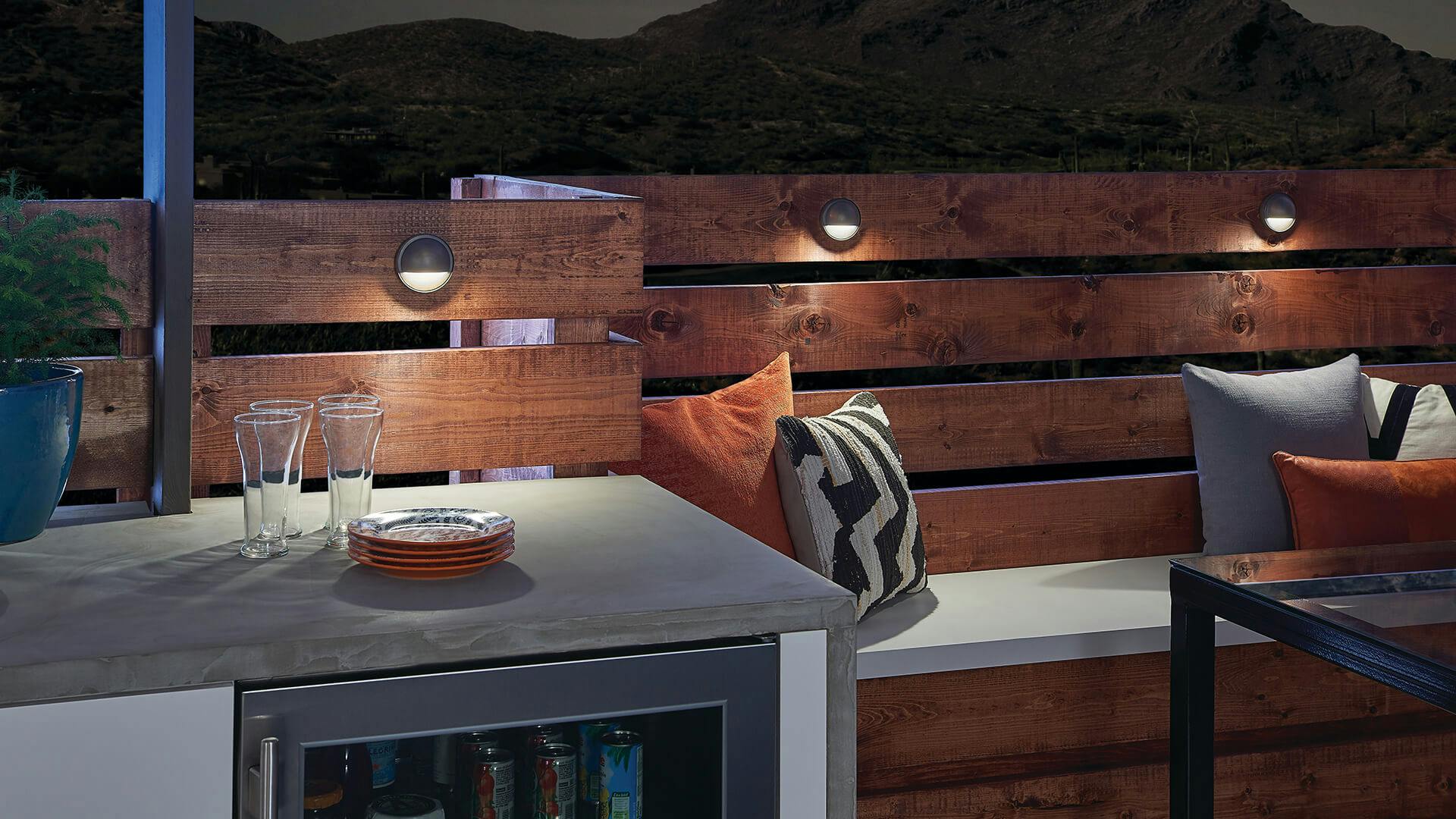 Outdoor kitchen at night with lights spaced out on the fencing