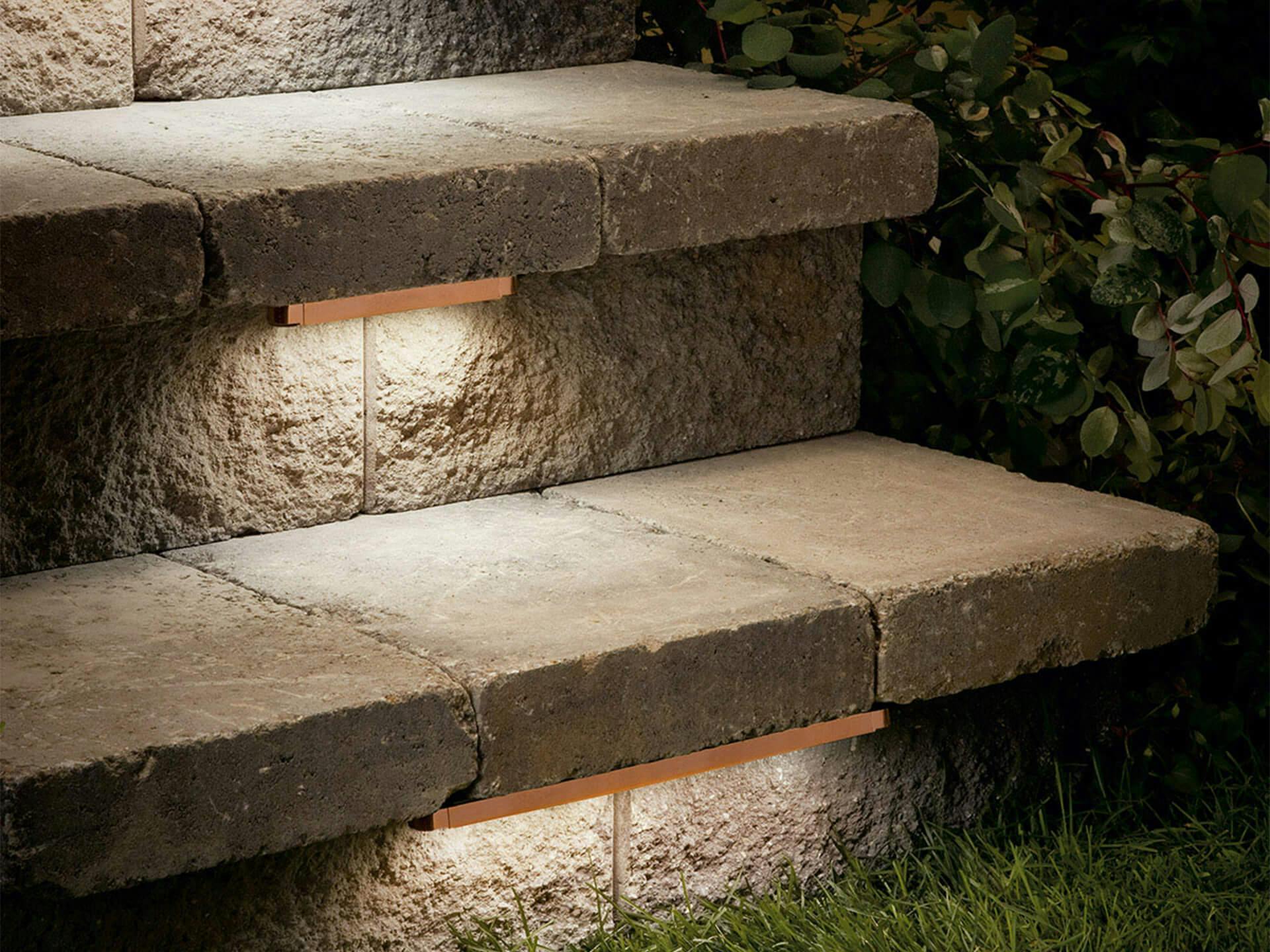 Stone stairs outside at night with lights downlighting each step