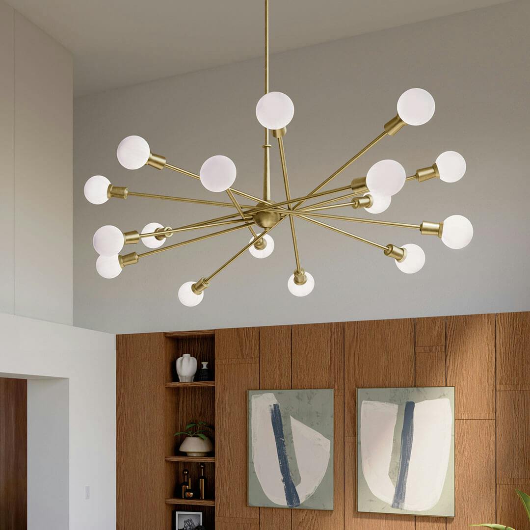 A lounge in daylight with the Armstrong 63" 16 Light Chandelier in Natural Brass