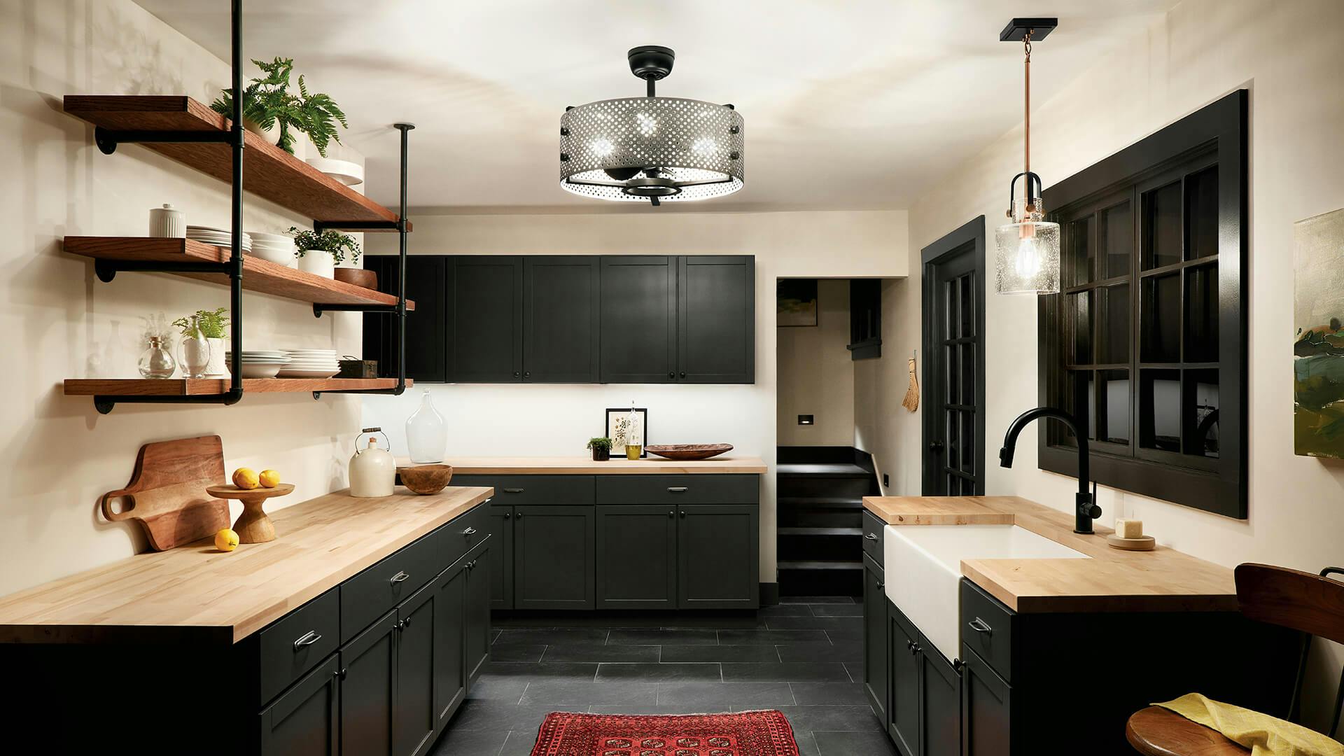 Kitchen at night with black cabinets and Eyrie chandelier in black finish